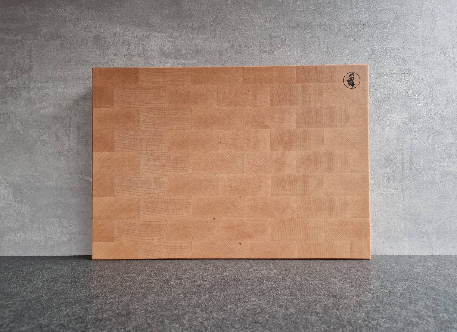 Stirnholz Schneidebrett aus Buche, stehend vor einer Betonwand