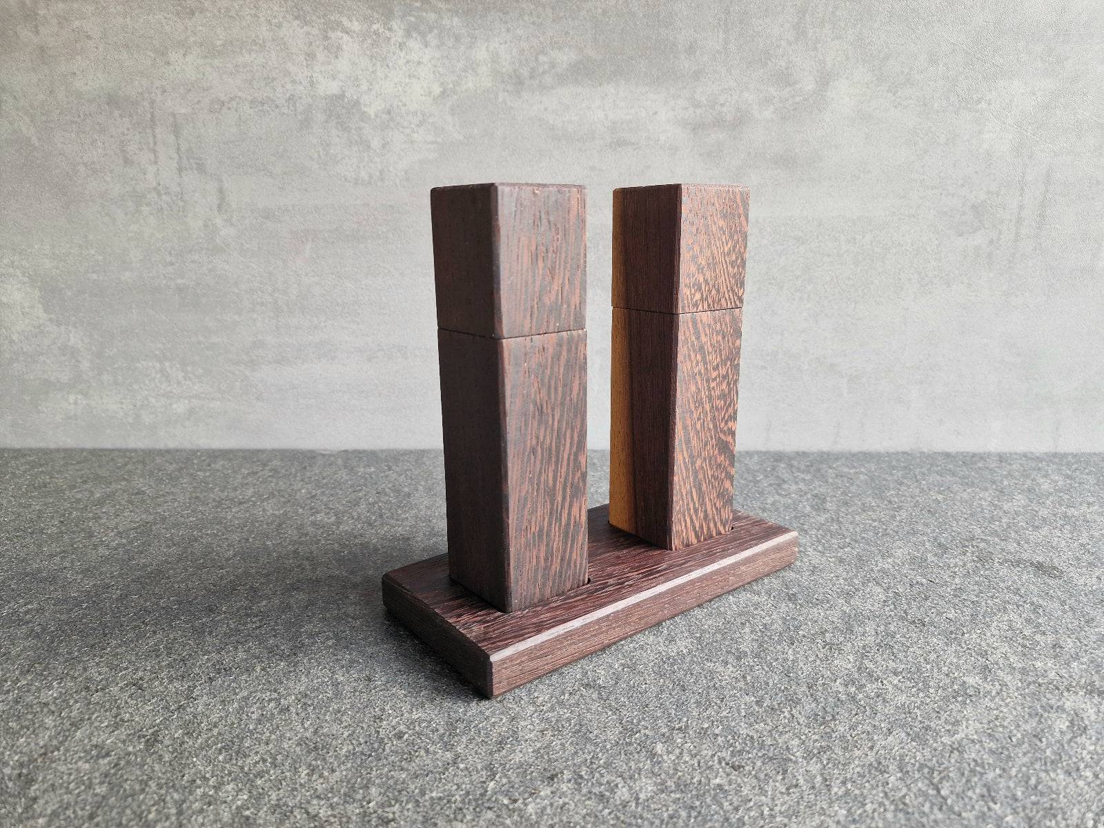 Rückansicht Wenge mit gelbem Splint Mühle und schwarz-braune Wenge Mühlen auf einem Holz Teller.