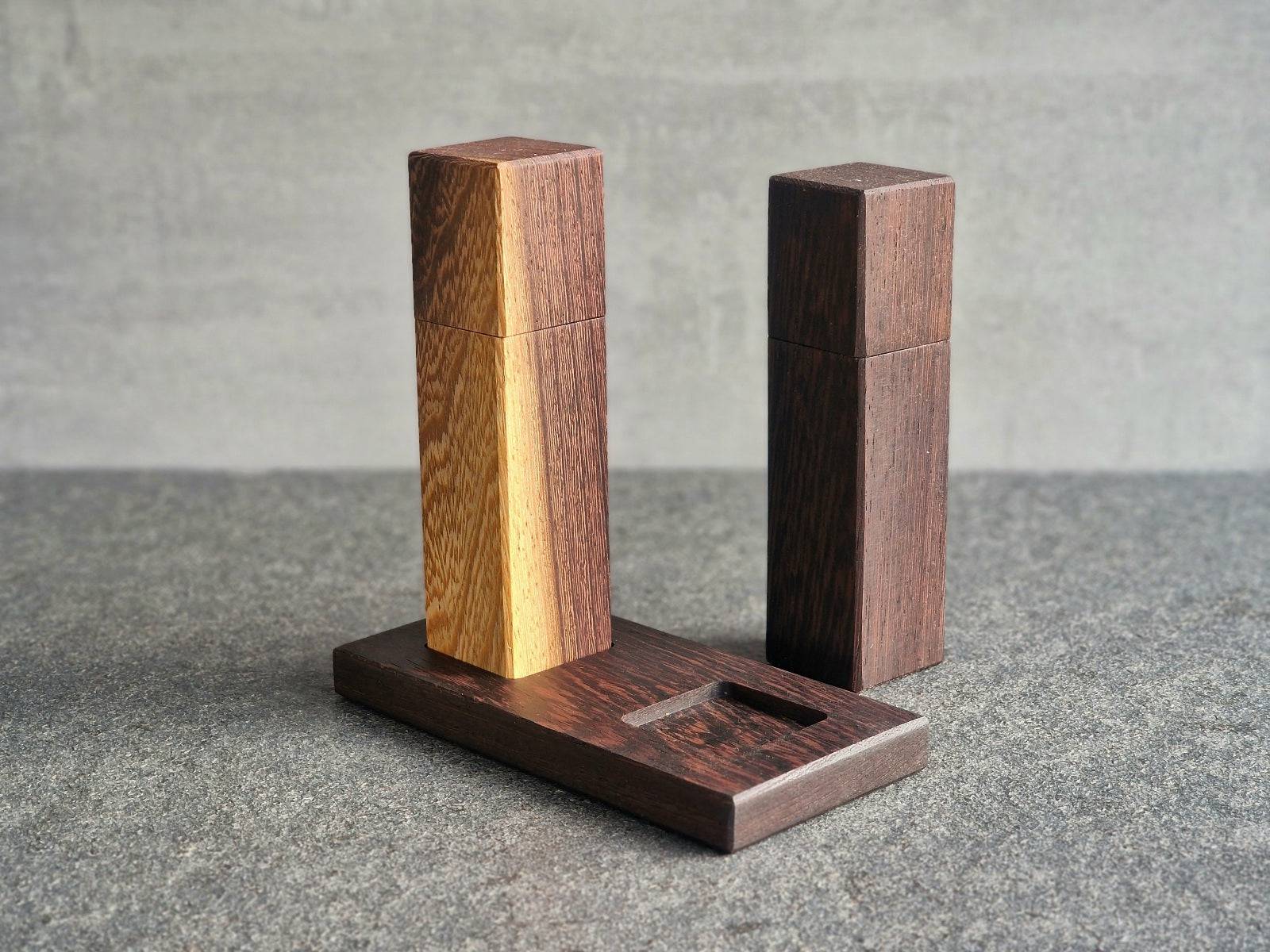 Spessartbrett Salz- und Pfeffermühle aus Wenge. Die Salzmühle steht auf einem Mühlenuntersetzer. Die Pfeffermühle daneben.