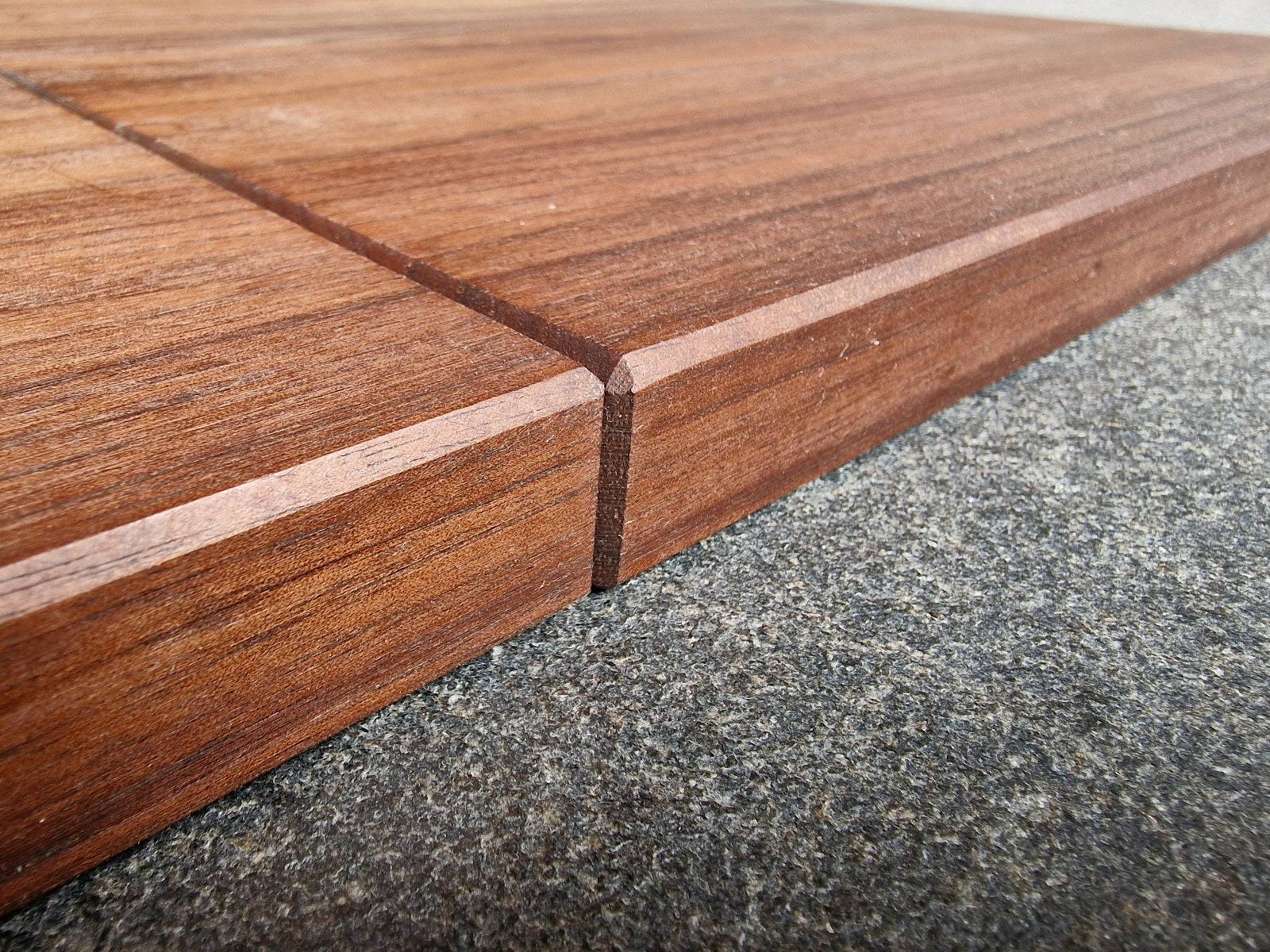 Detailaufnahme der Anschläge von einer Kochfeldabdeckung aus Nussbaum.