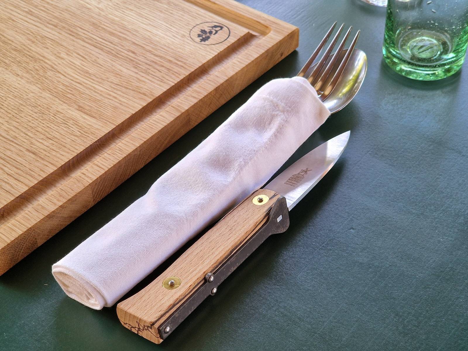 Dekorierter Essplatz mit einem Eiche Holzteller mit Saftrille, Silberbesteck und Steakmesser Lierenaar mit Eisbuche Griff