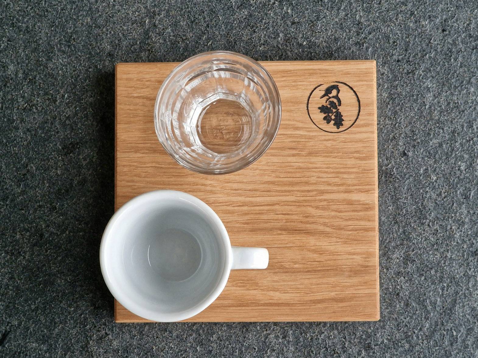 Espressotablett aus Eiche mit Glas und Tasse von oben , auf einer Steinplatte.