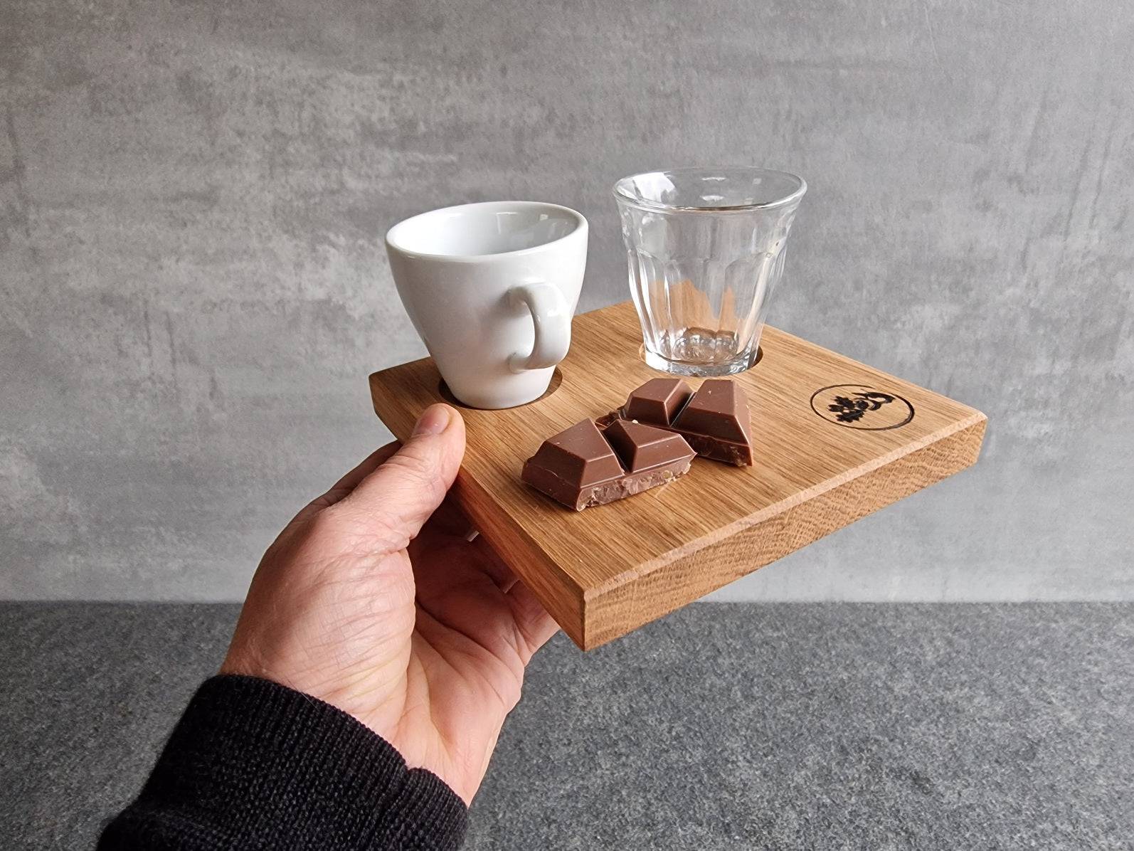 Hand hält ein stilvolles Espressotablett.