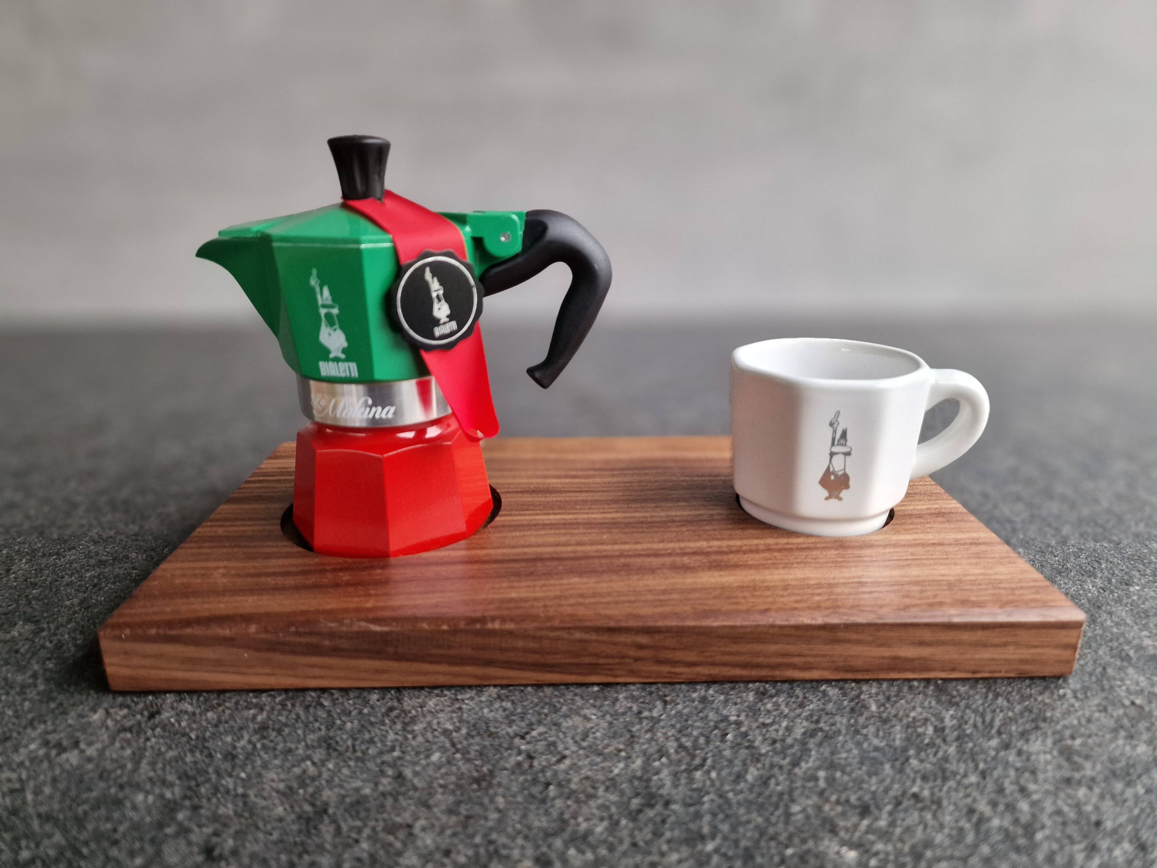 Espressokocher von bialetti und einer weißen Bialetti Espressotasse und einem Nussbaum Holztablett