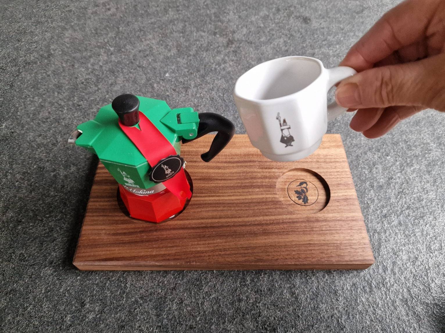 Hand hält weiße Bialetti Espressotasse