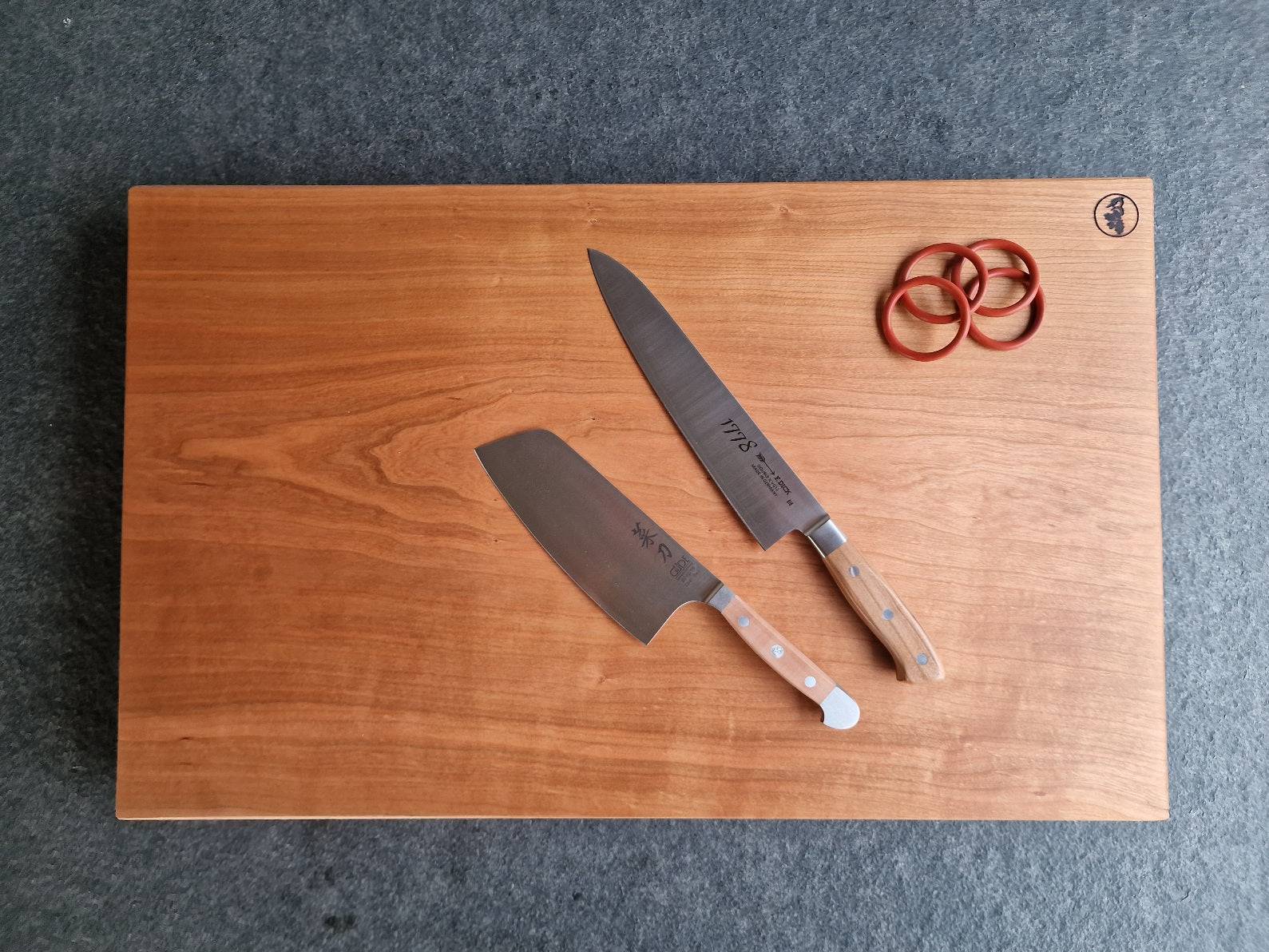 Schneideblock aus Kirschbaum mit Gummiringen und einem Kochmesser von Dick und Güde.