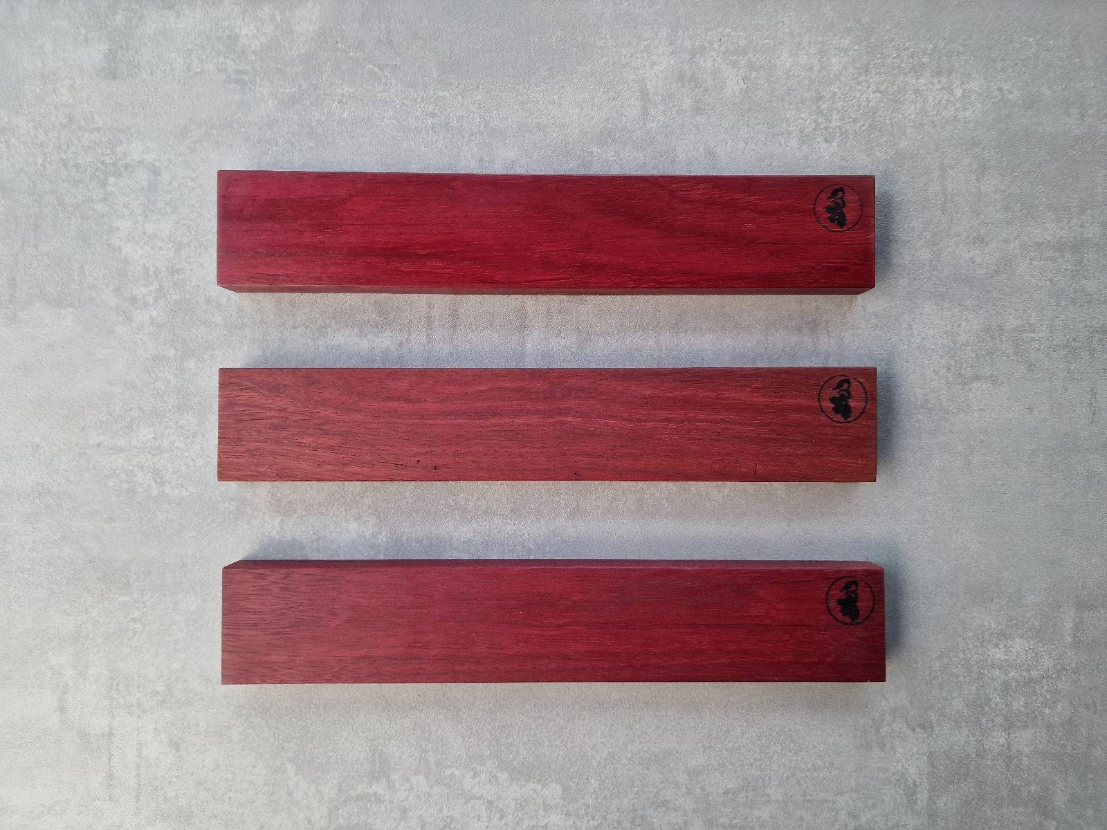 3 verschiedene Amaranth Wand Messerhalter für 6 Messer an einer Betonwand.