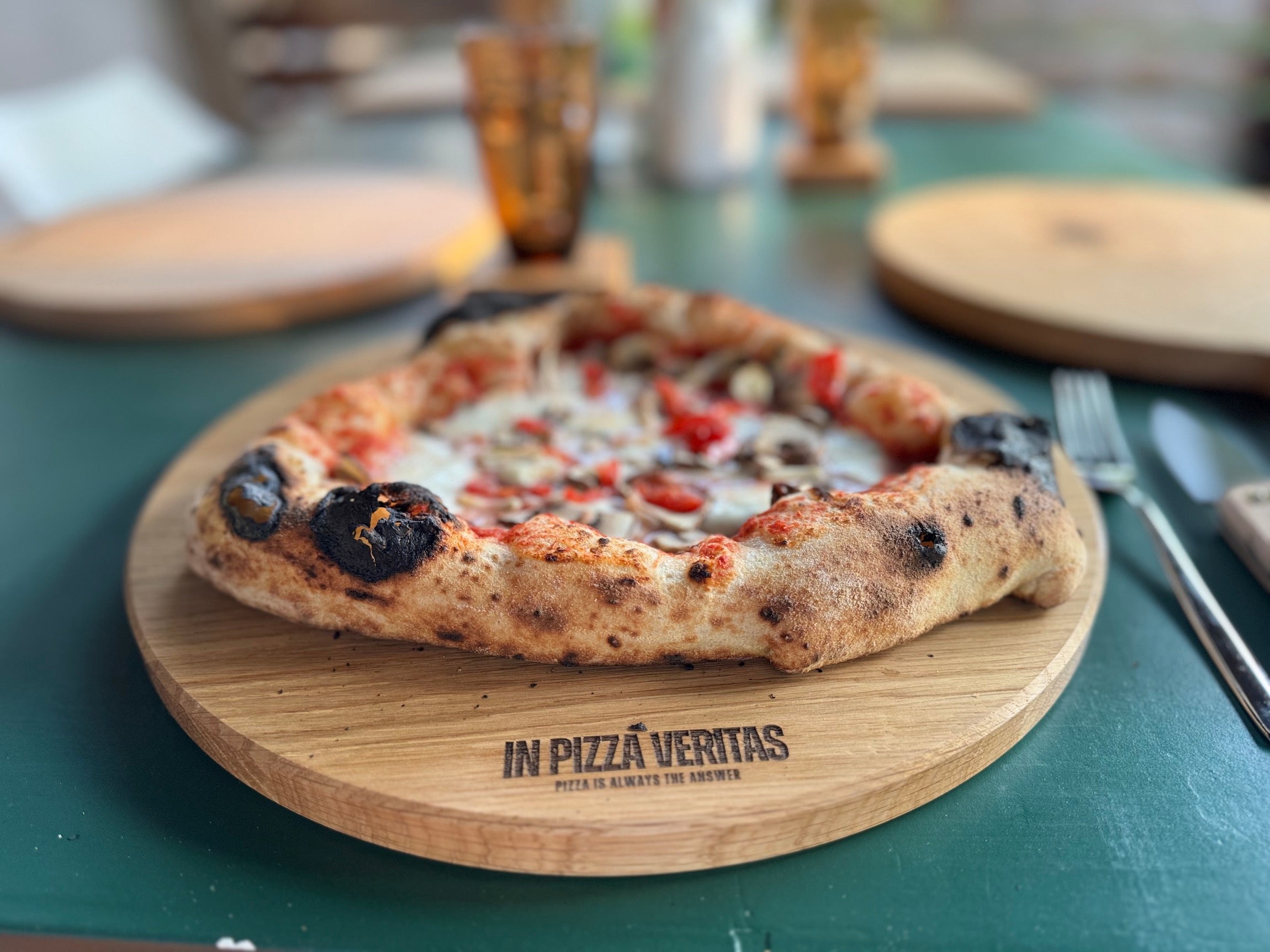 Neapolitanische Pizza auf einem Pizzabrett „In Pizza Veritas“.