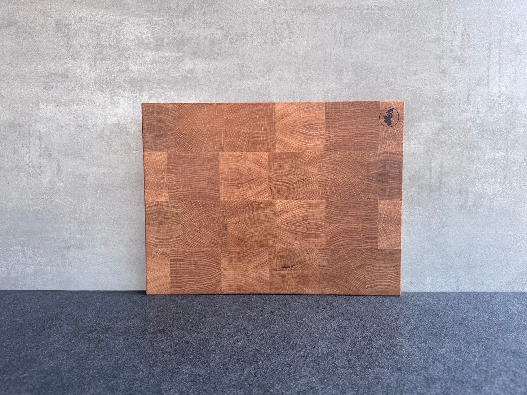 40 cm breites Eiche Hirnholz Schneidebrett an einer Betonwand.