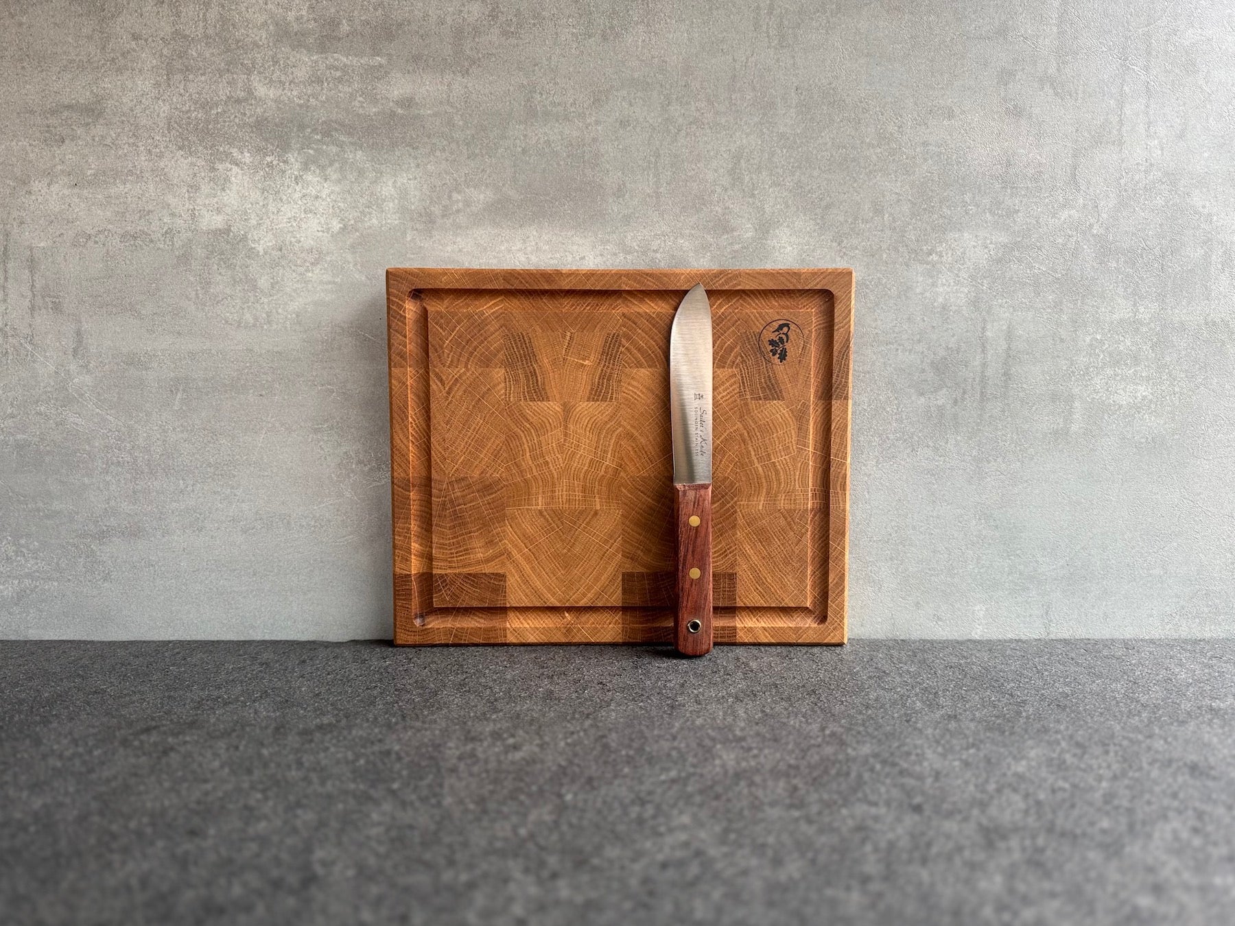 Steakbrett aus Eiche Hirnholz mit Saftrille und einem Güde Messer.
