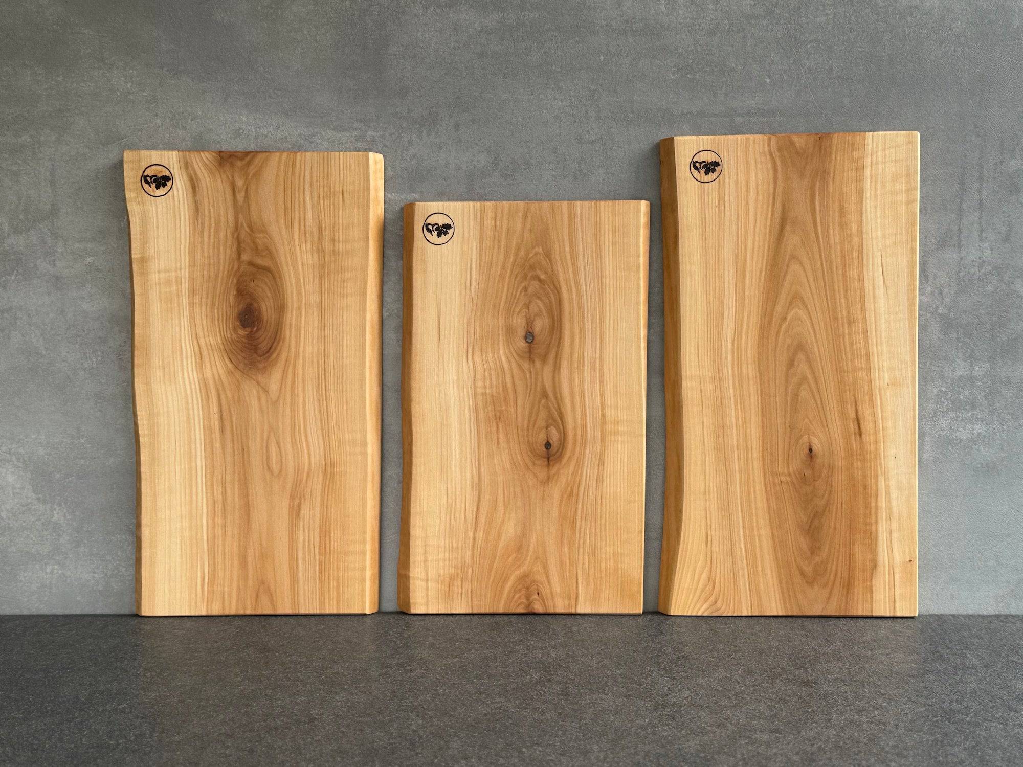 3 tolle Schneidebretter aus heimischer Vogelbeere an einer Betonwand.