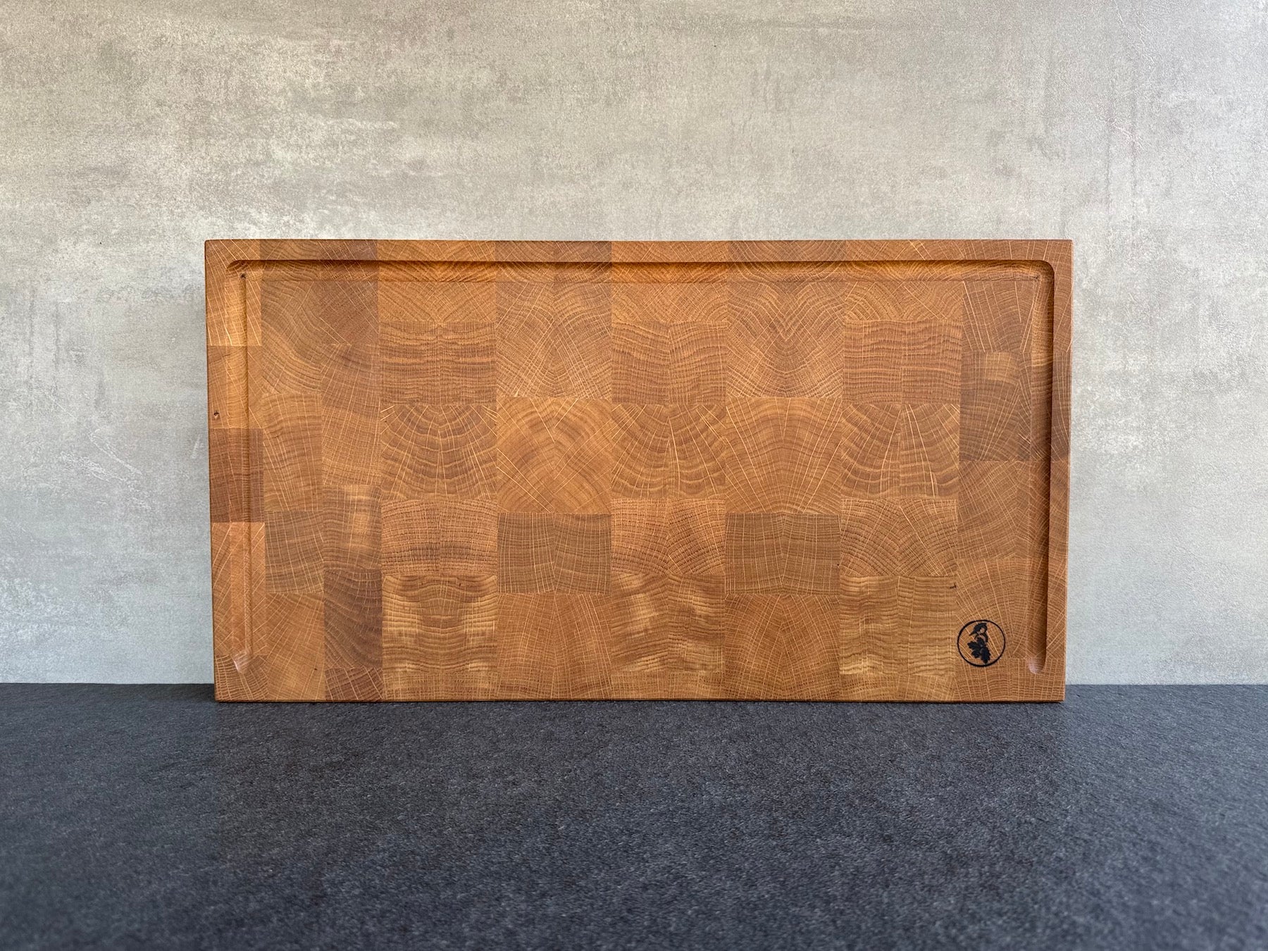 Eiche Hirnholz Schneideblock mit U-Saftrille und Griffmulden.