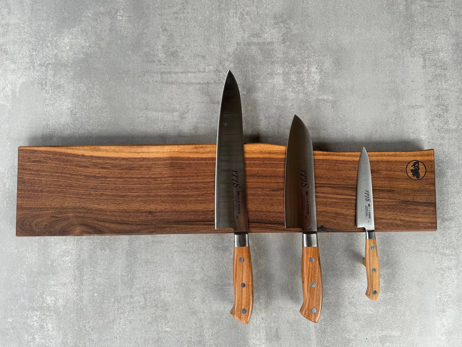 Magnetische Messerleiste für 9 Messer aus massivem Nussbaum mit einer Baumkante. Dekoriert mit 3 Kochmessern von Dick 1778.