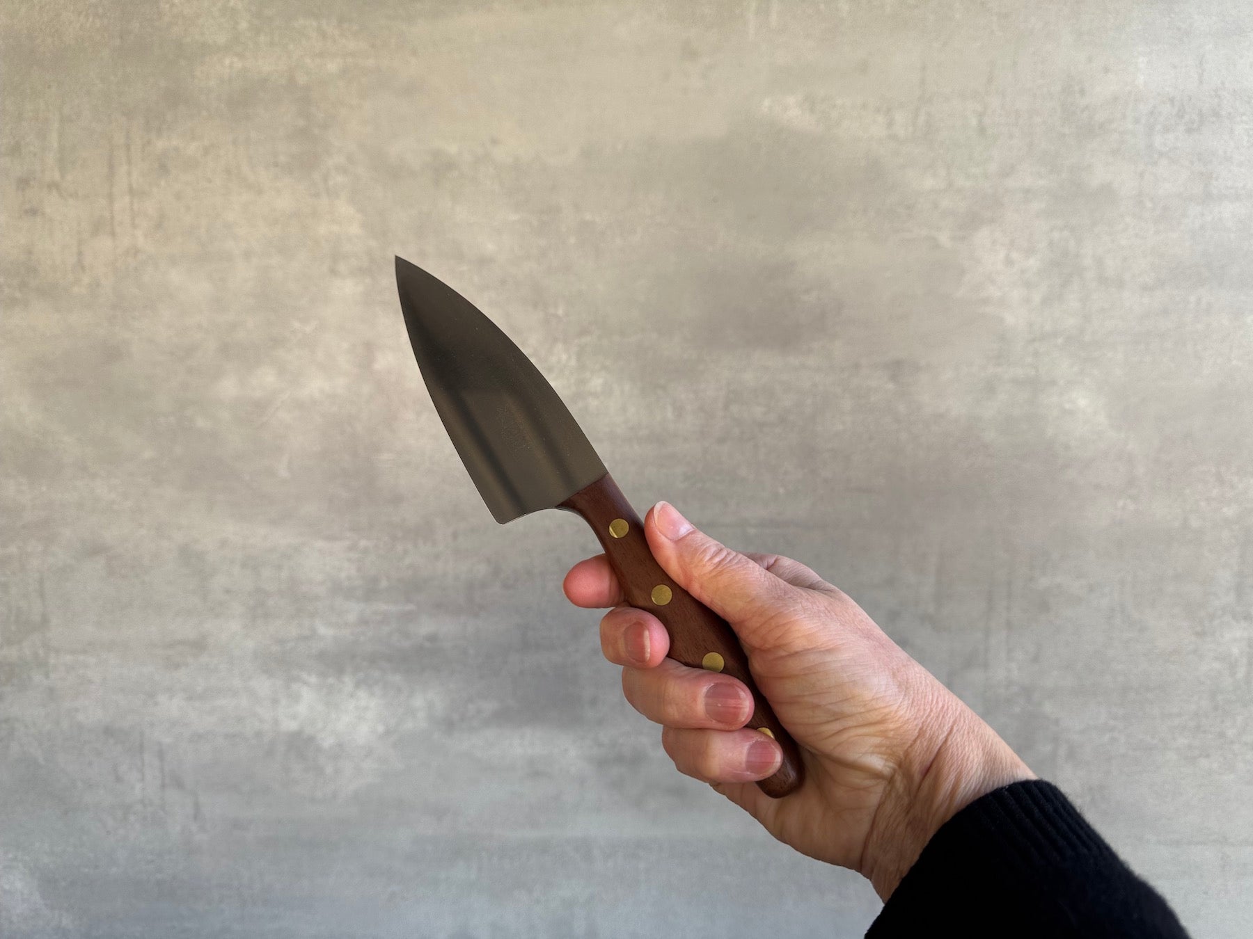 Hand hält das K4 Kochmesser in der Hand.