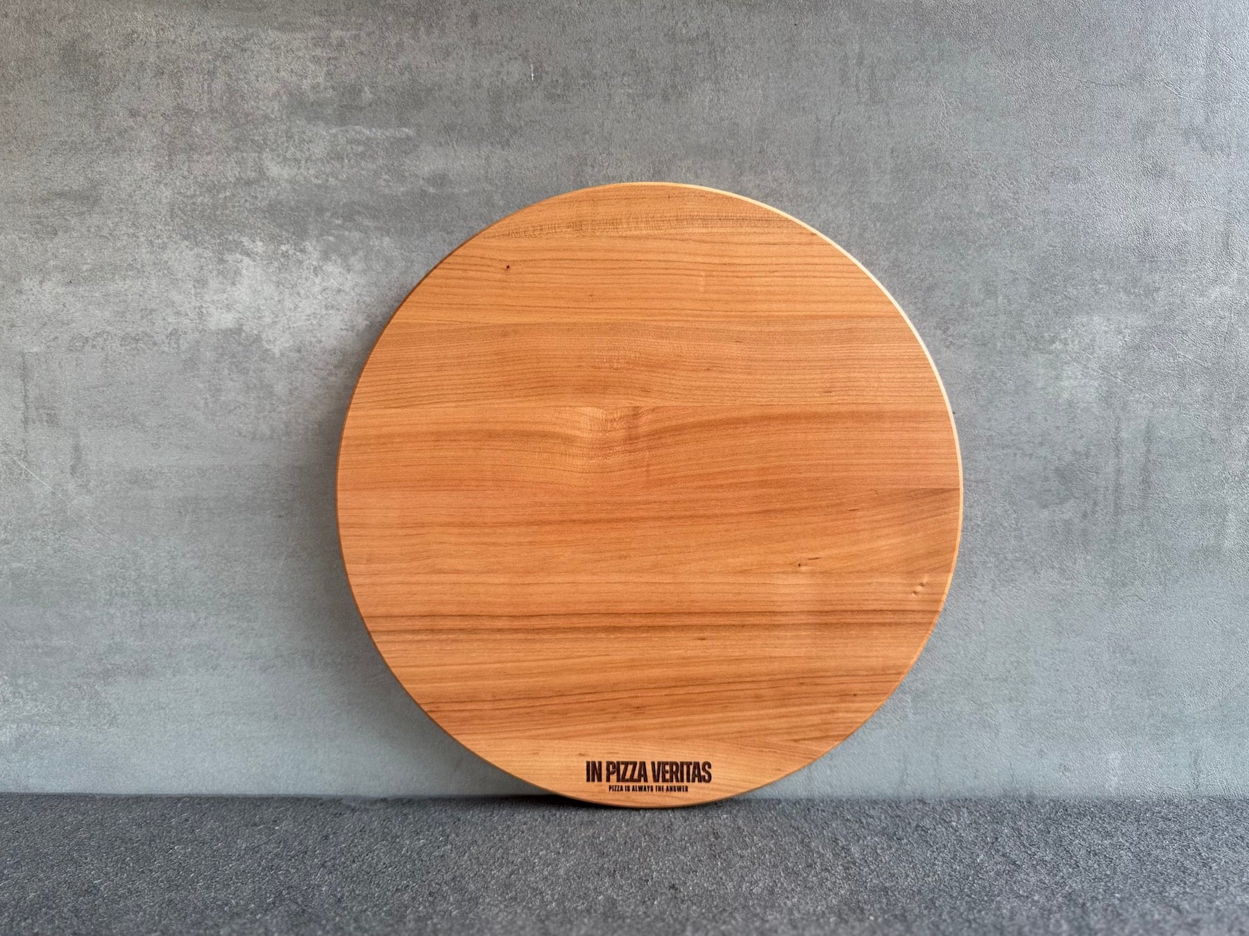 Rundes Pizzabrett aus Kirschholz mit feiner Gravur „In Pizza Veritas“.
Erhältlich in 35 cm und 40 cm