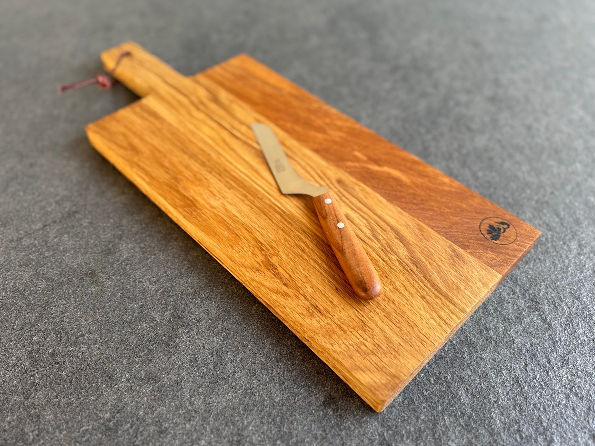 Eichenbrett mit Griff und Lederband und einem Käsemesser