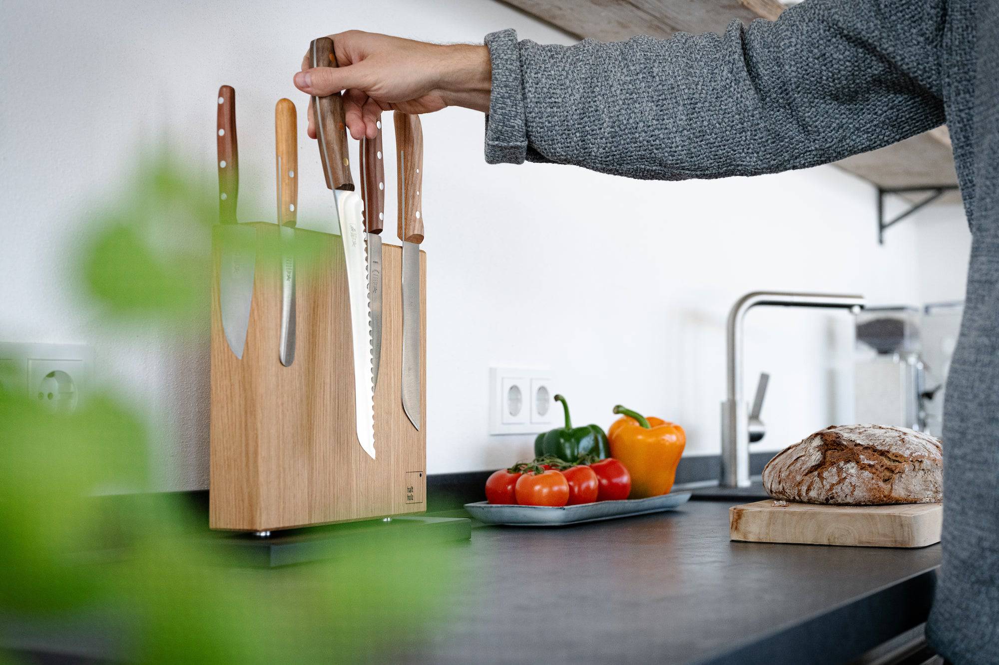 Hand nimmt ein Windmühlen Brotmesser von einem magnetischen Messerhalter
