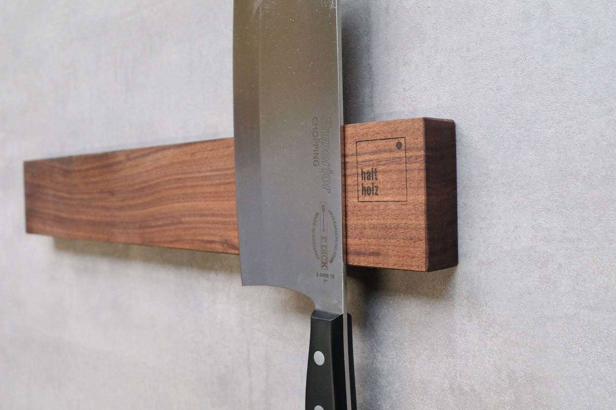 Großes Gemüsemesser an magnetischem Nussbaum-Messerhalter an der Wand