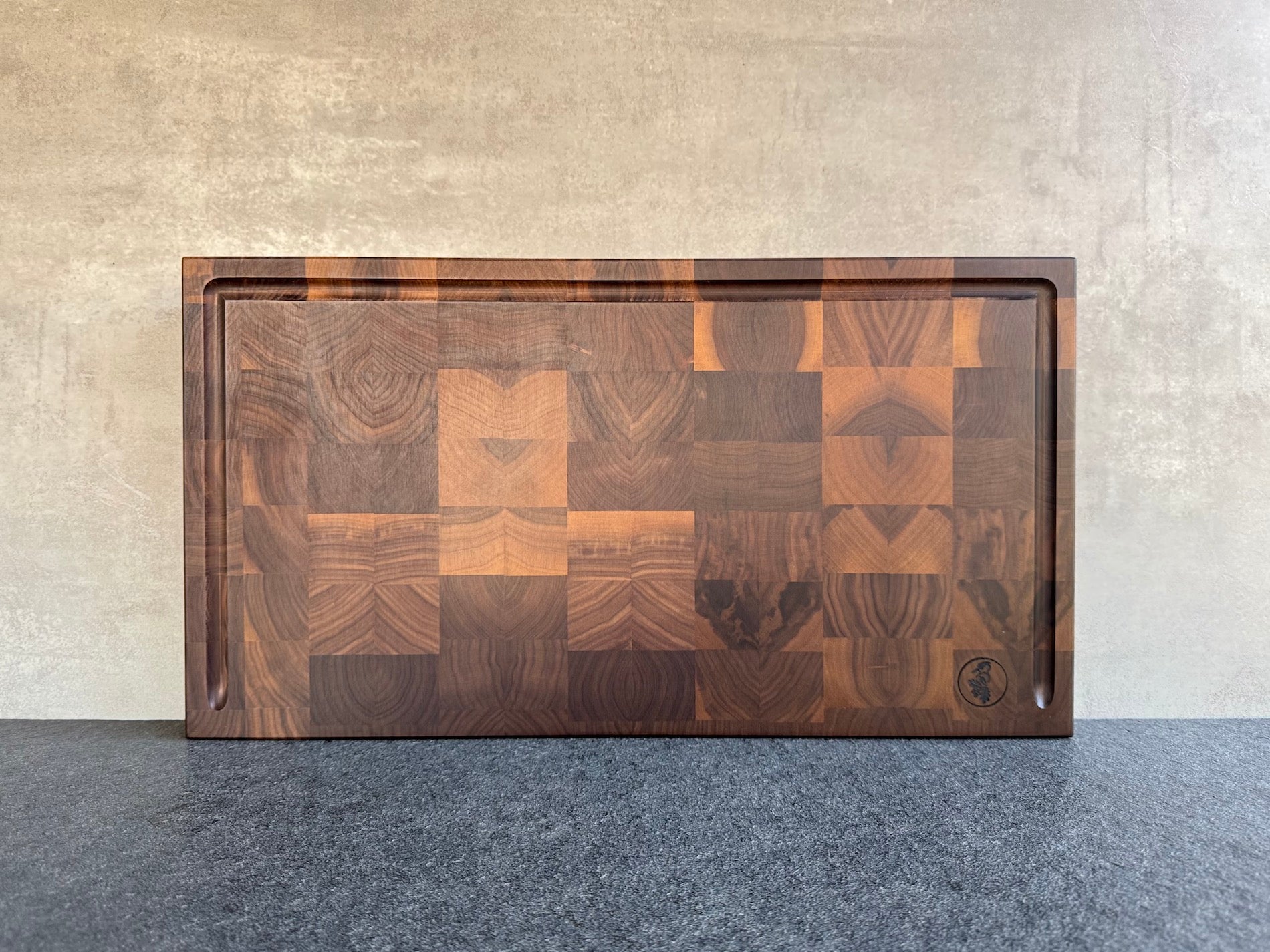 55 cm breiter Nussbaum Hirnholz Schneidebrett mit U-Saftrille und Griffmulden.