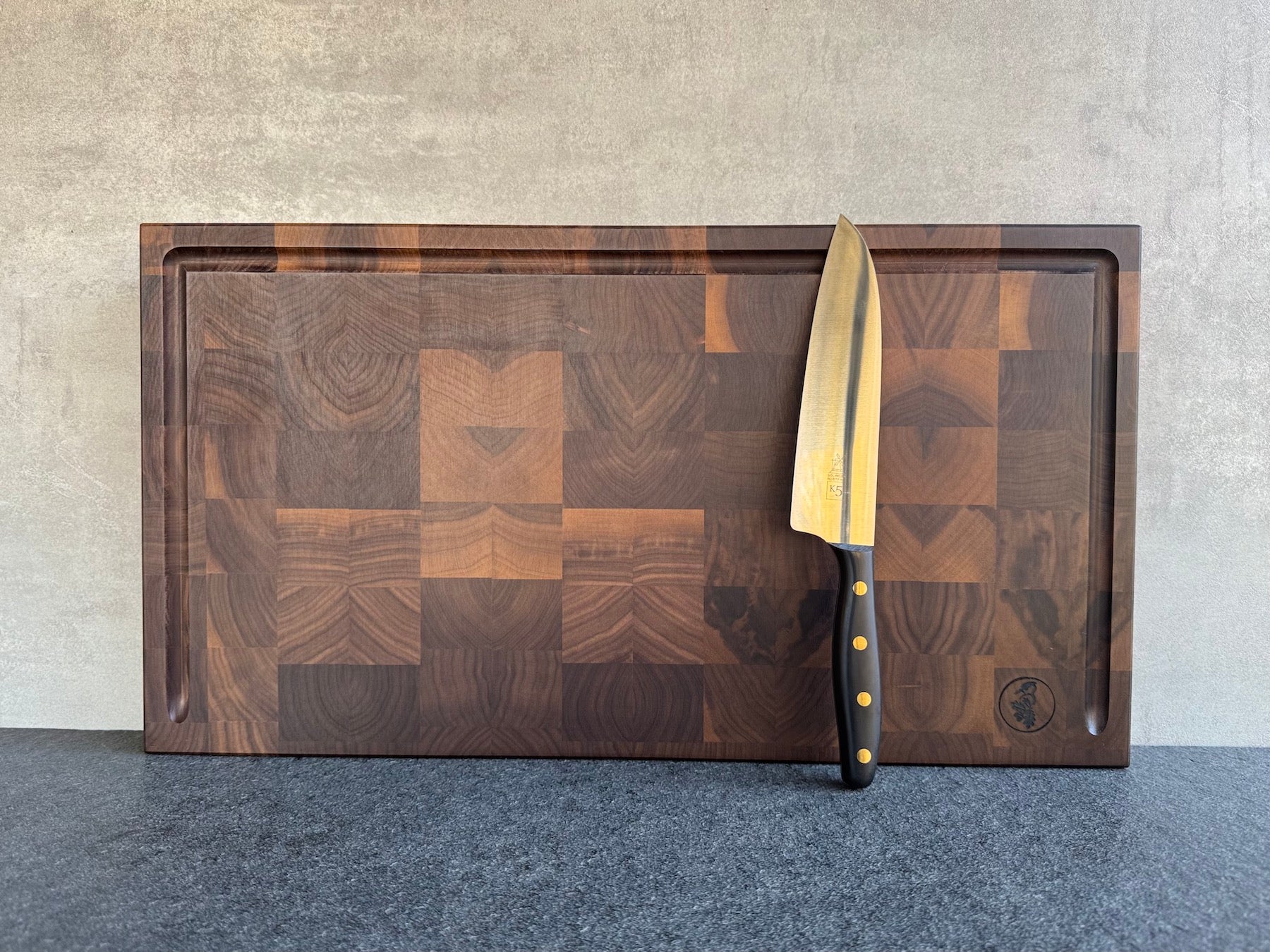 Nussbaum Hirnholz Schneideblock mit Saftrille und Griffmulden.