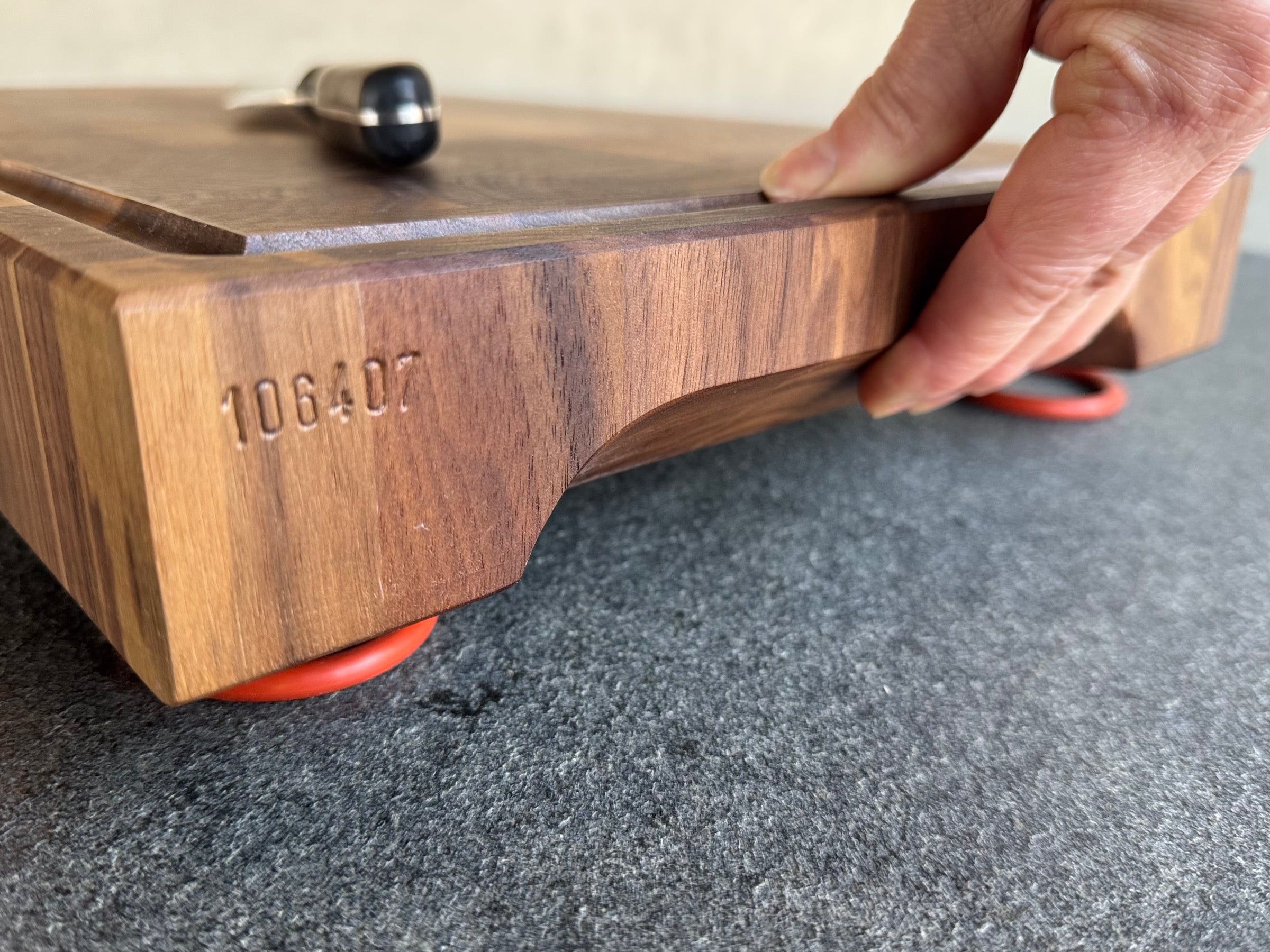 Hand hält Griffmulden eines Schneideblocks aus Hirnholz.