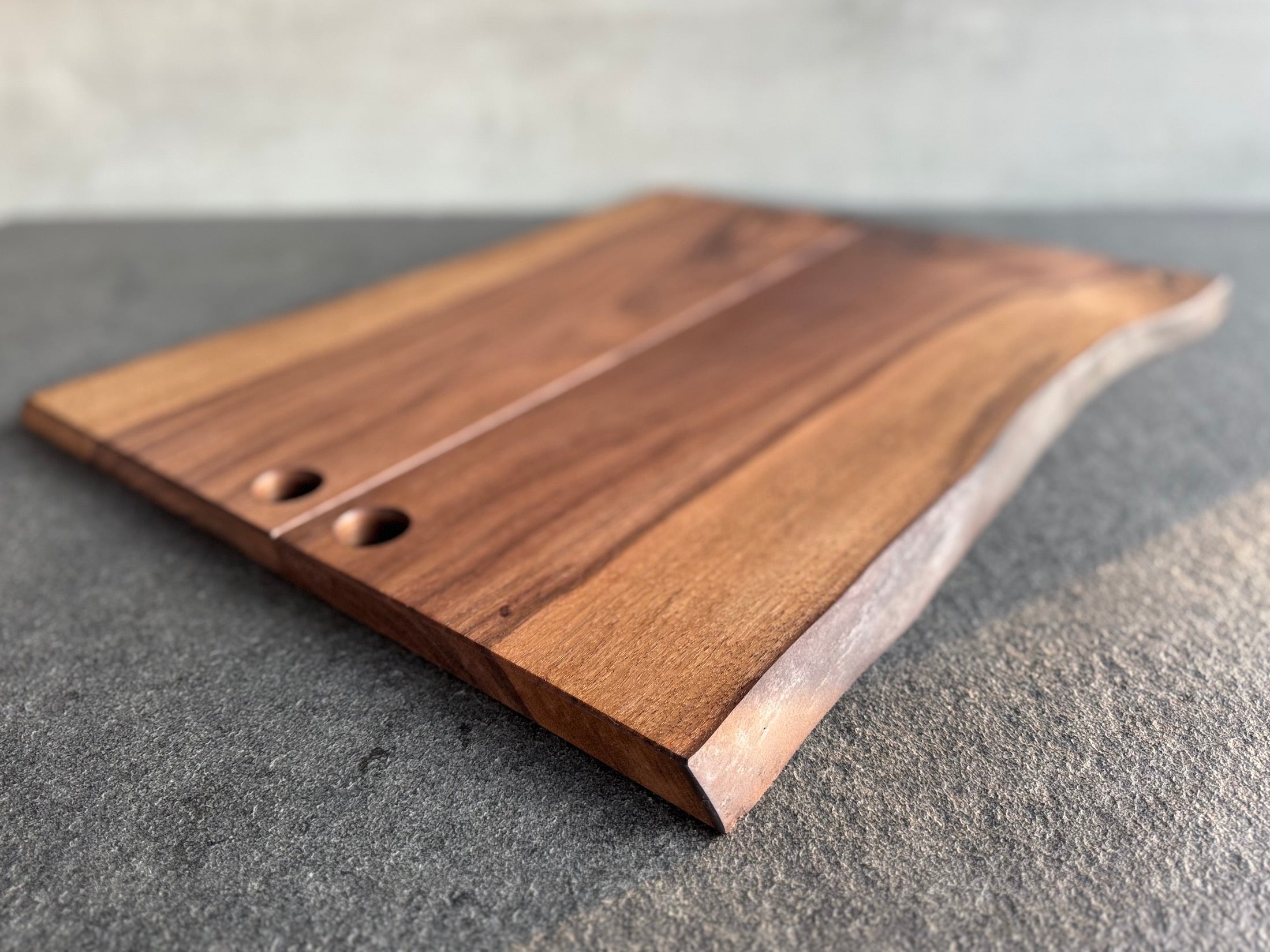 Servierbretter aus einem Stück Nussbaum mit einem Aufhängeloch.