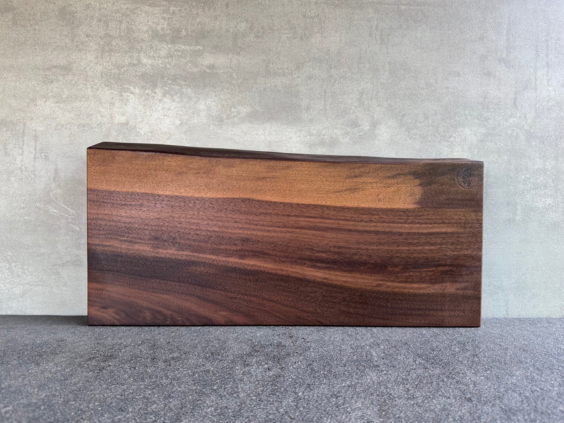 Vollholz Schneideblock aus massivem Nussbaum, über 50 cm breit, mit einer Baumkante.