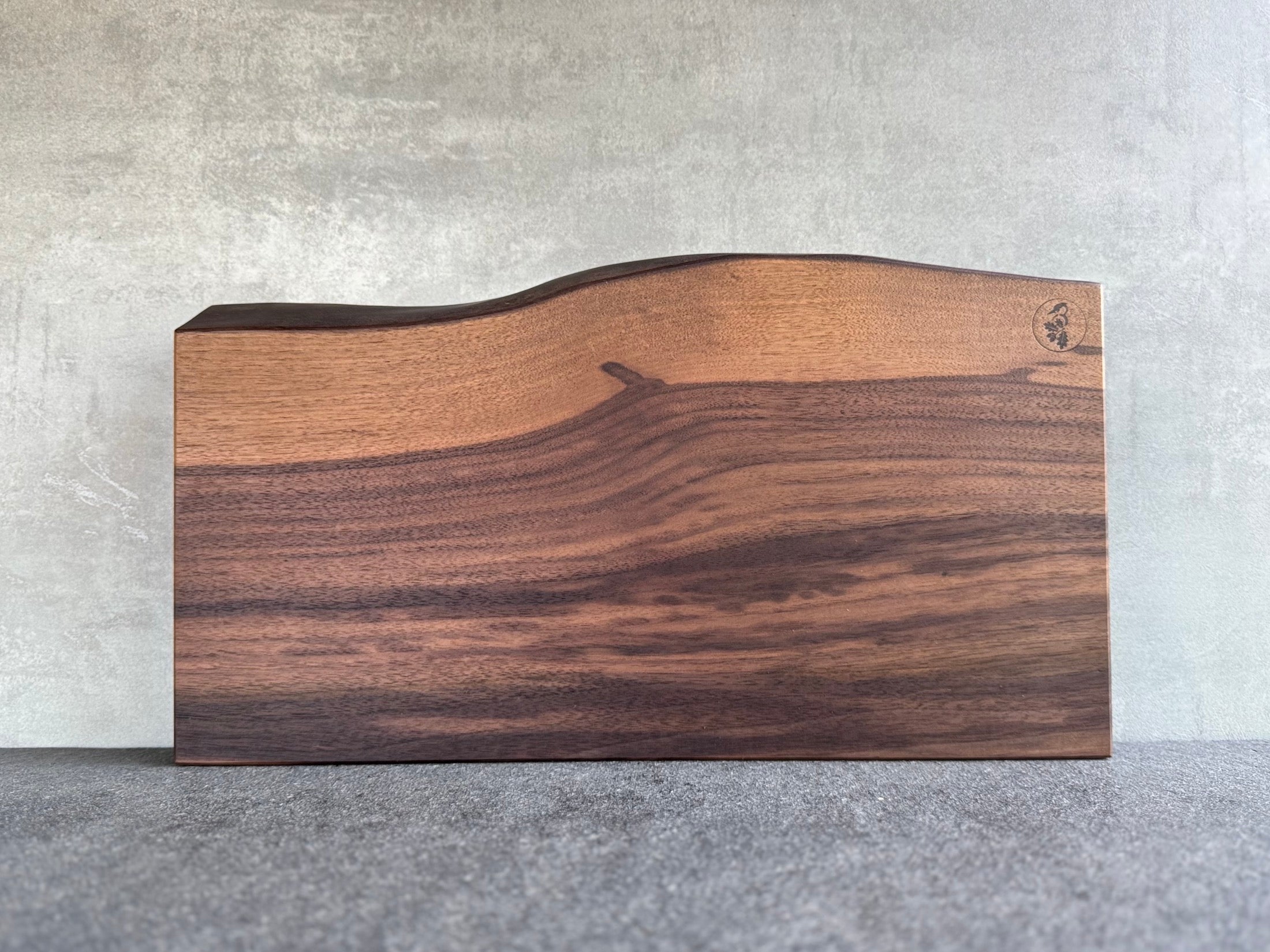 Schneidebrett aus einem Stück Nussbaum mit wundervoll geschwungener Baumkante.