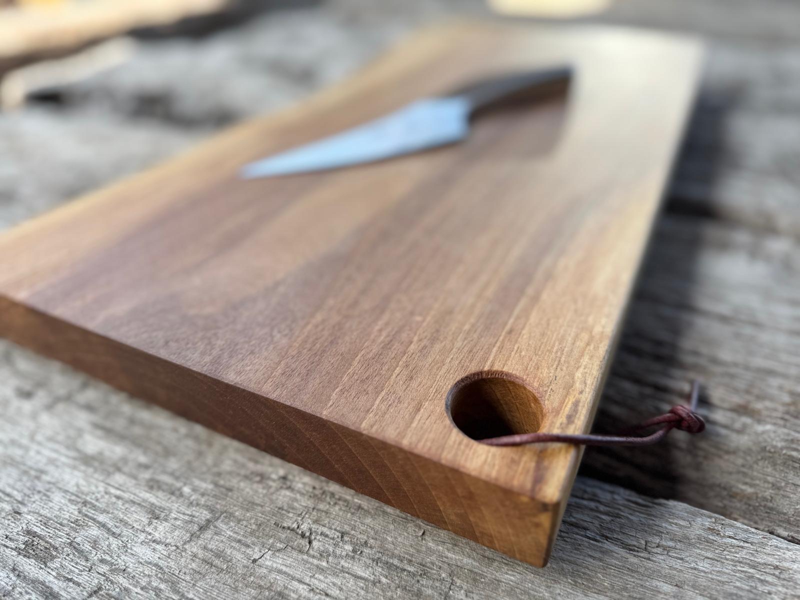 Detailansicht eines Grifflochs mit einem Lederbändel bei einem Schneideblock