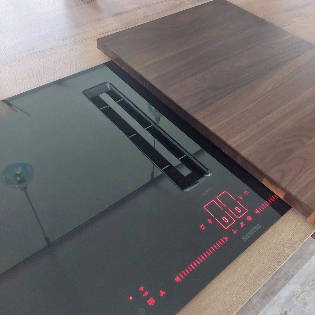 Siemens Kochfeld mit integriertem Dunstabzug und einer halben Kochfeldabdeckung aus Nussbaum.