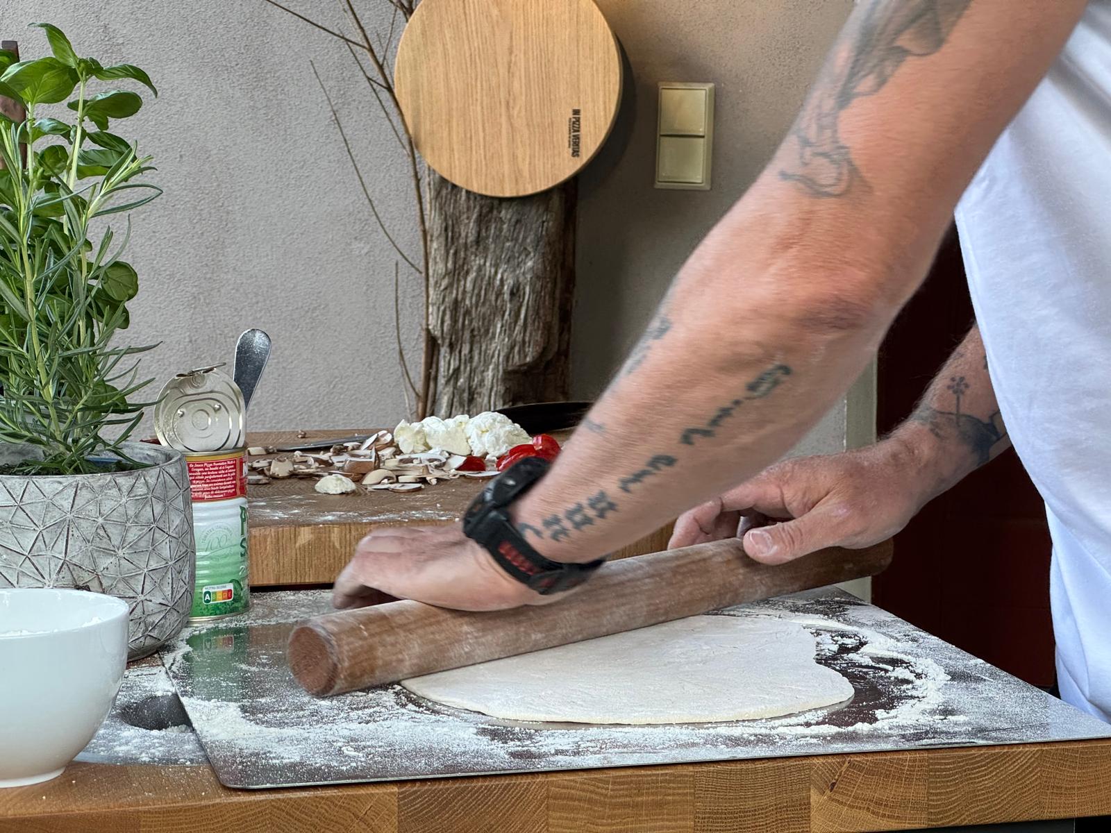 Pizzateig und Teigrolle auf einem Edelstahlbackblech von Gi.Metal