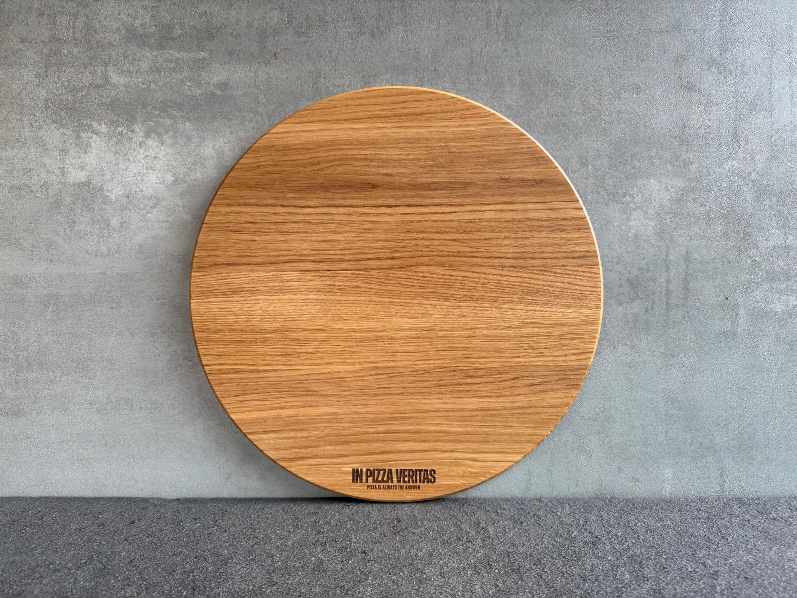 Rundes Pizzabrett aus Eichenholz mit feiner Gravur „In Pizza Veritas“.
Erhältlich in 35 cm Durchmesser.