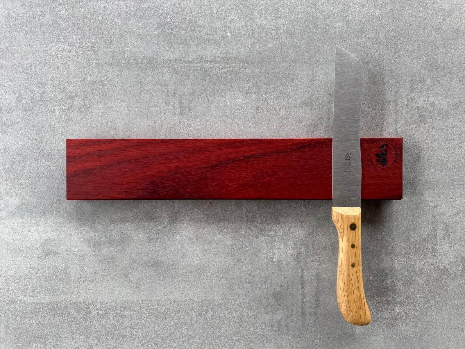 Messerleiste aus leuchtend rotem Padouk für 6 Messer. Dekoriert mit einem Brotmesser Hamburger.