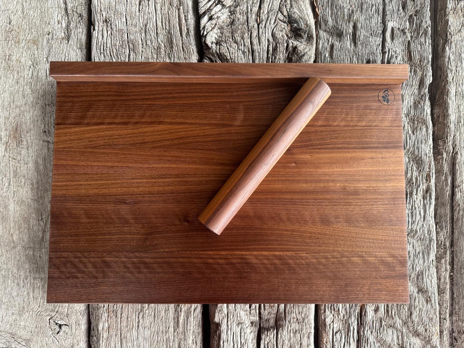 Ansicht von oben eines Backbrett mit Anschlägen aus Nussbaum. Mit einer Teigrolle aus Nussbaum.