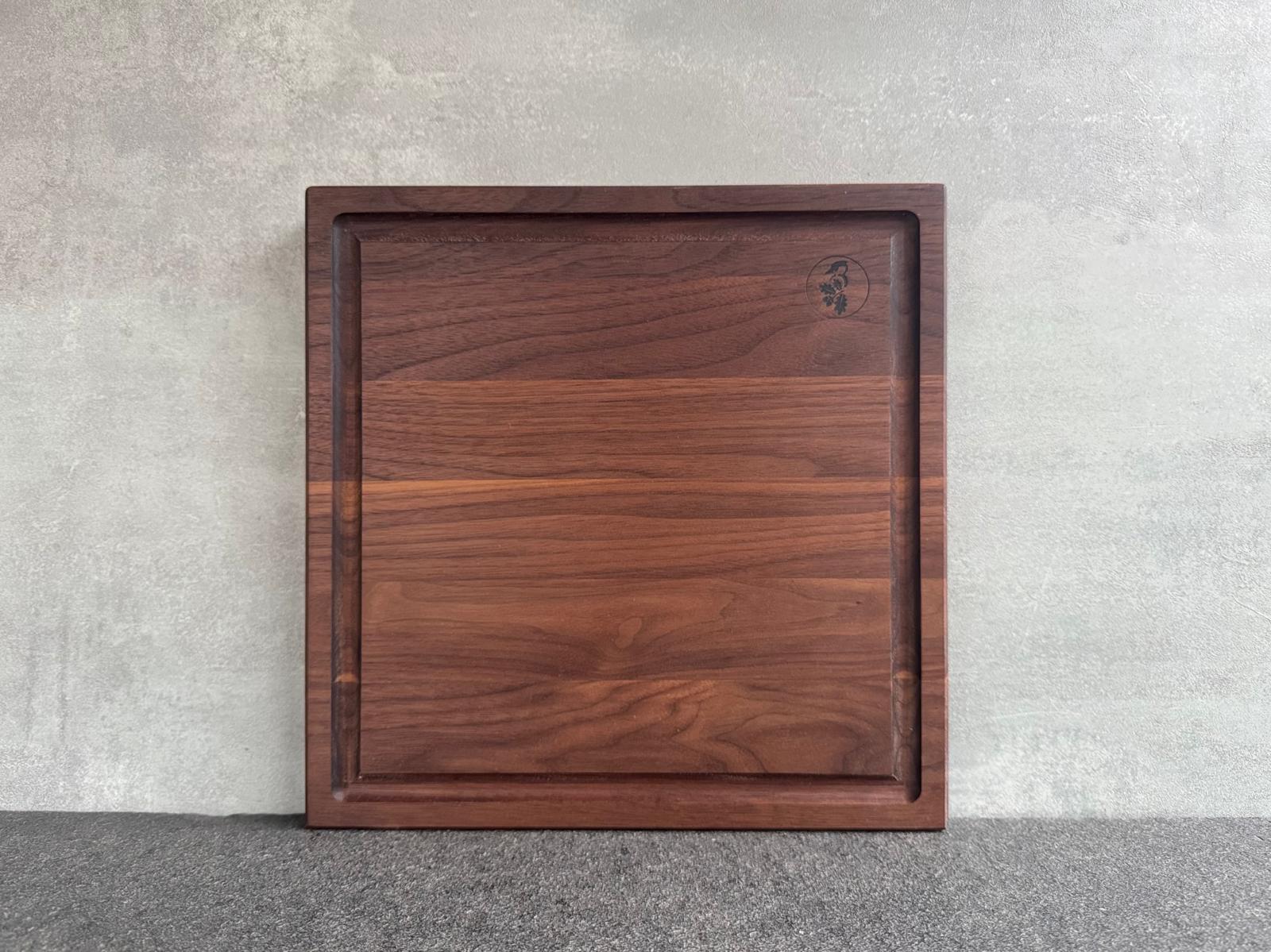 Quadratisches Schneidebrett mit Saftrille aus Nussbaum massiv.