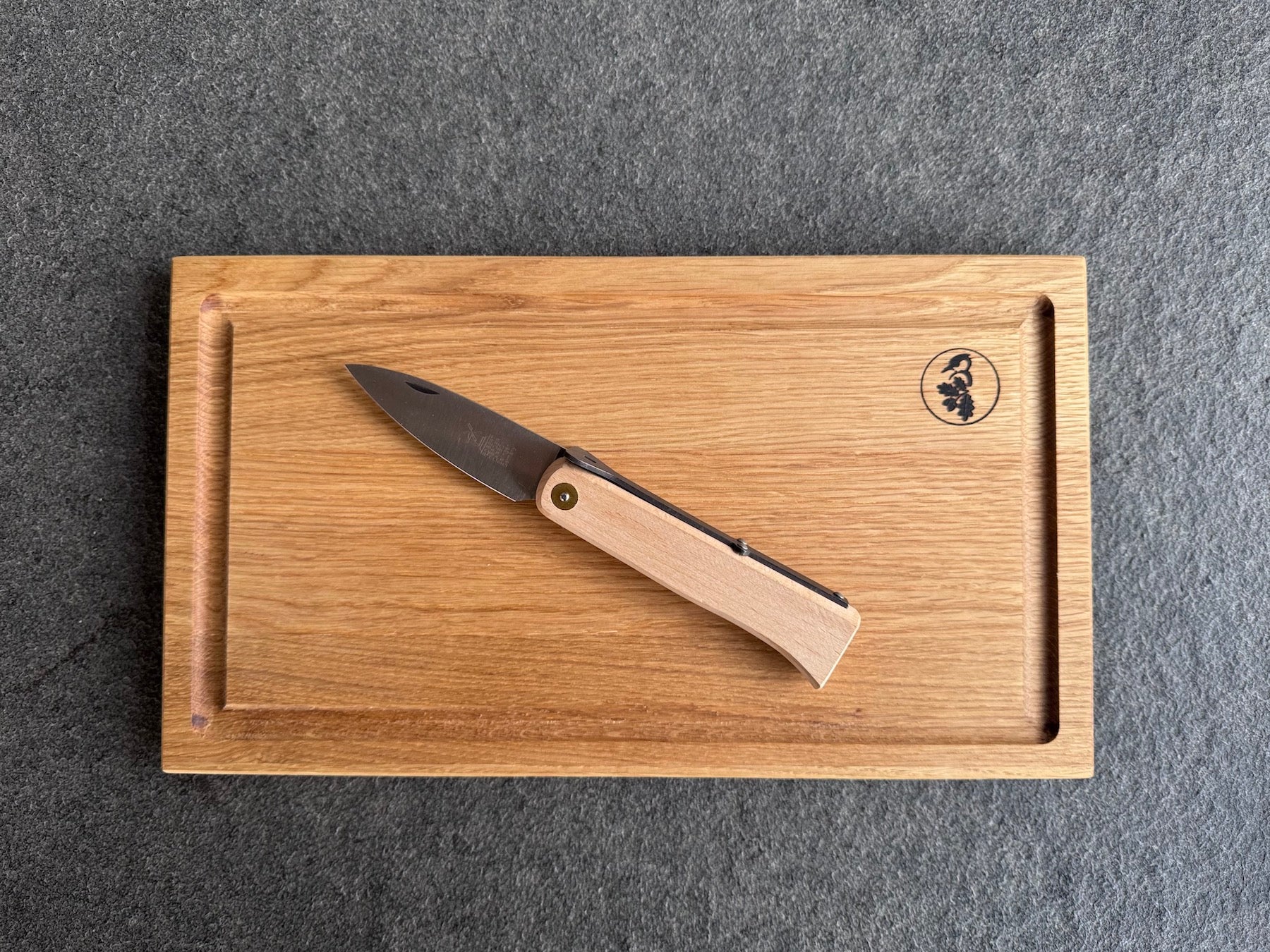 Steakbrett mit Saftrille aus Eiche mit einem Steakmesser.