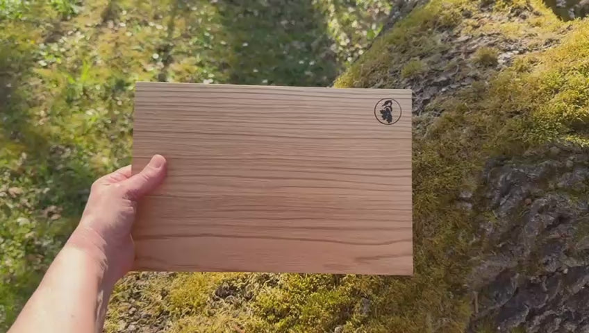 Kurzfilm von einem Schneidebrett mit schrägen Kanten aus einem Stück Eiche vor einer bemoosten Eiche.