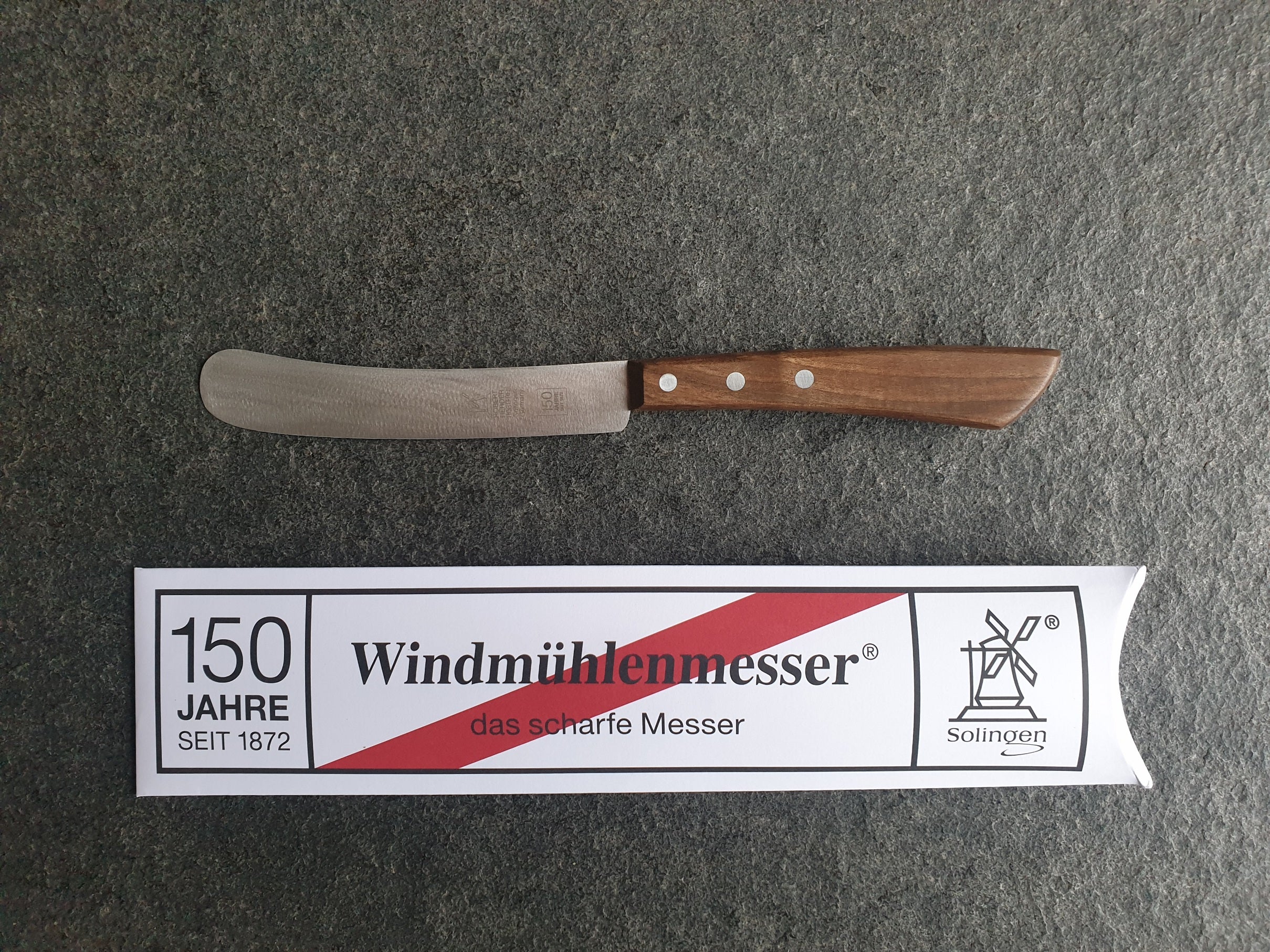 Jubiläums-Edition 150 Jahre Windmühlenmesser. Buckels mit 13 cm Klinge und Nussbaum-Griff. Besondere Verpackung.