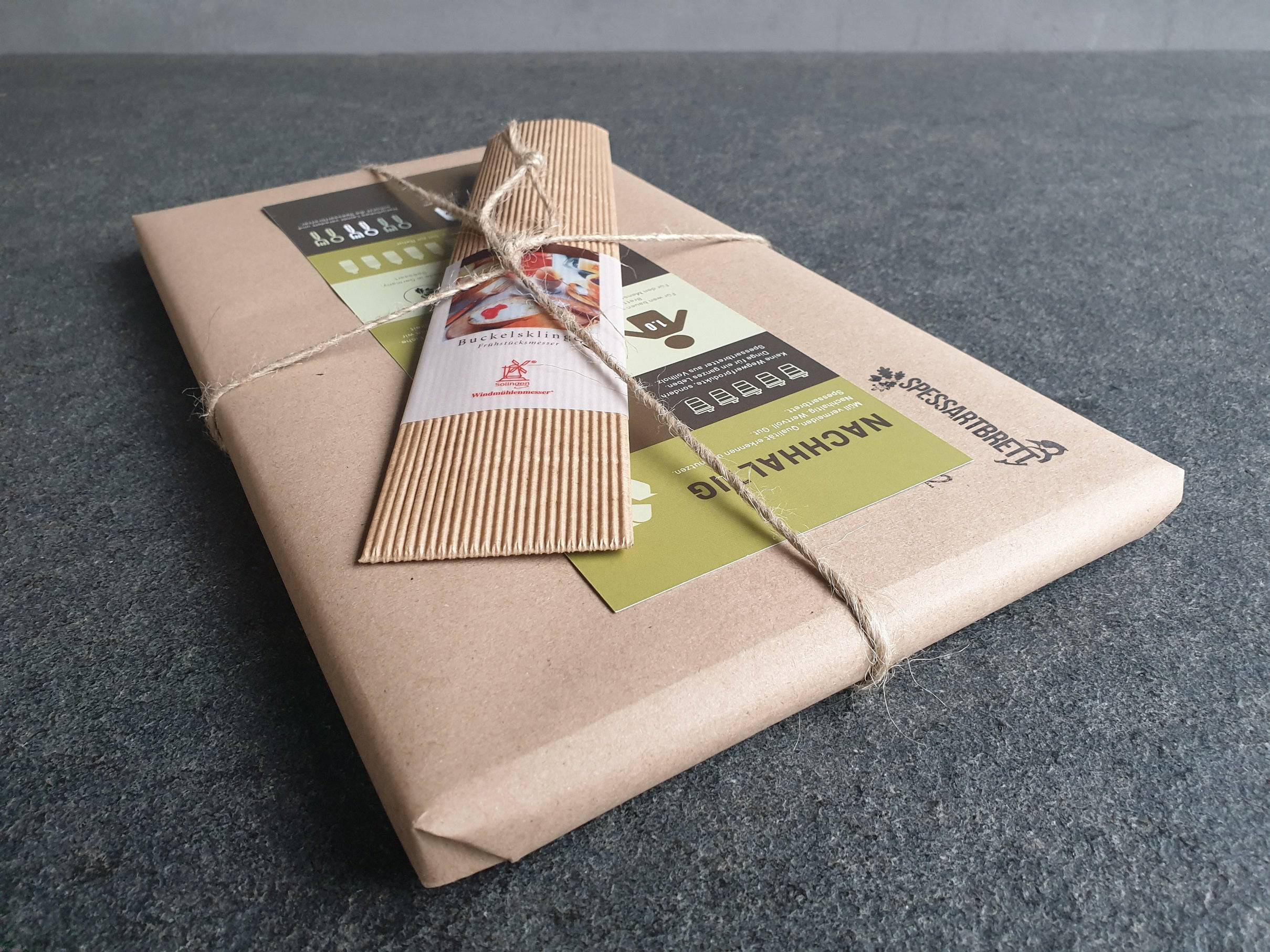 Abschiedsgeschenk, nachhaltig verpackt. Inhalt ein Nussbaum Brett und ein Vespermesser mit Nussbaum Griff.