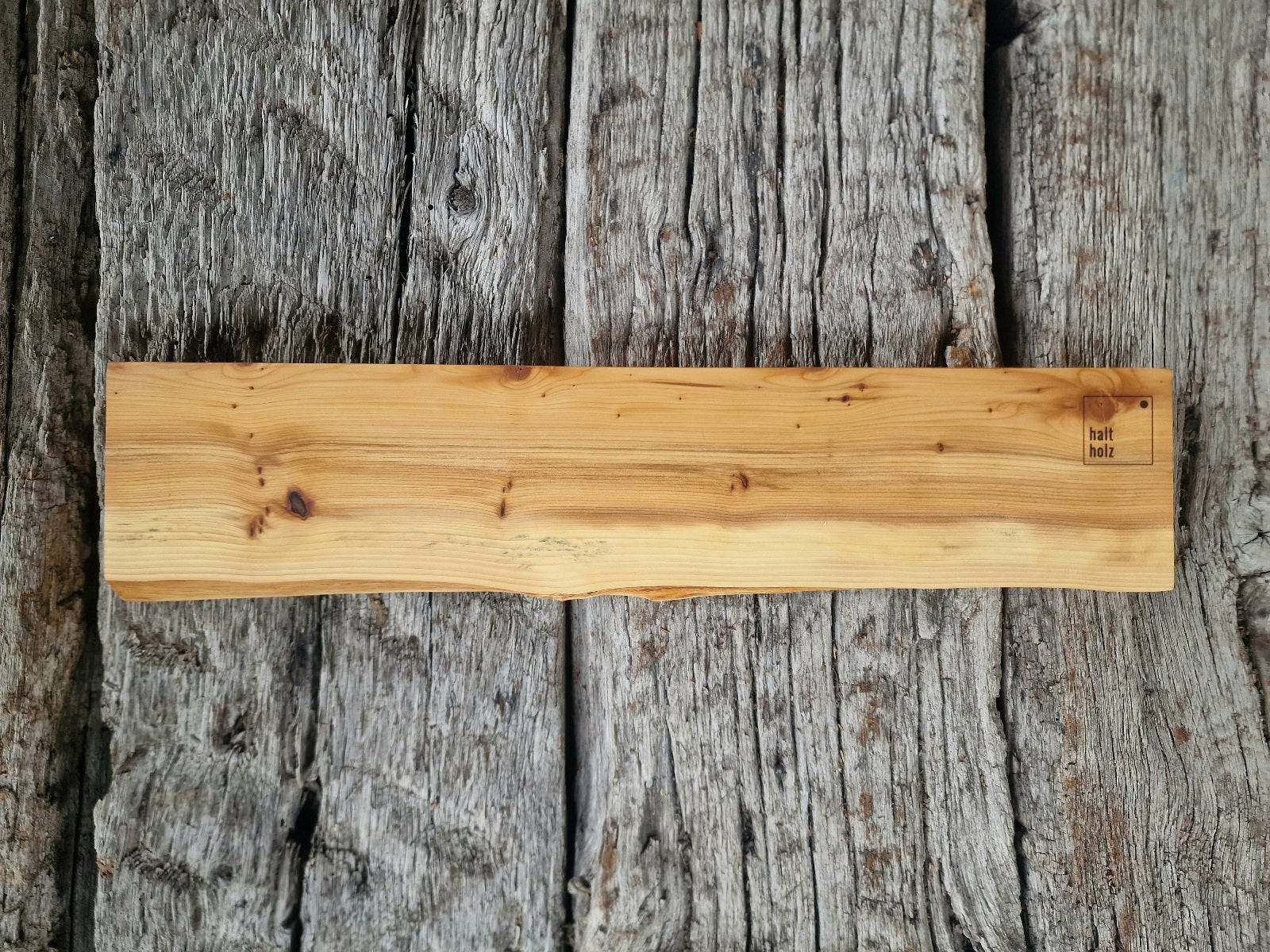 Messerleiste aus Eibenholz mit Baumkante auf alten Eichenbalken.