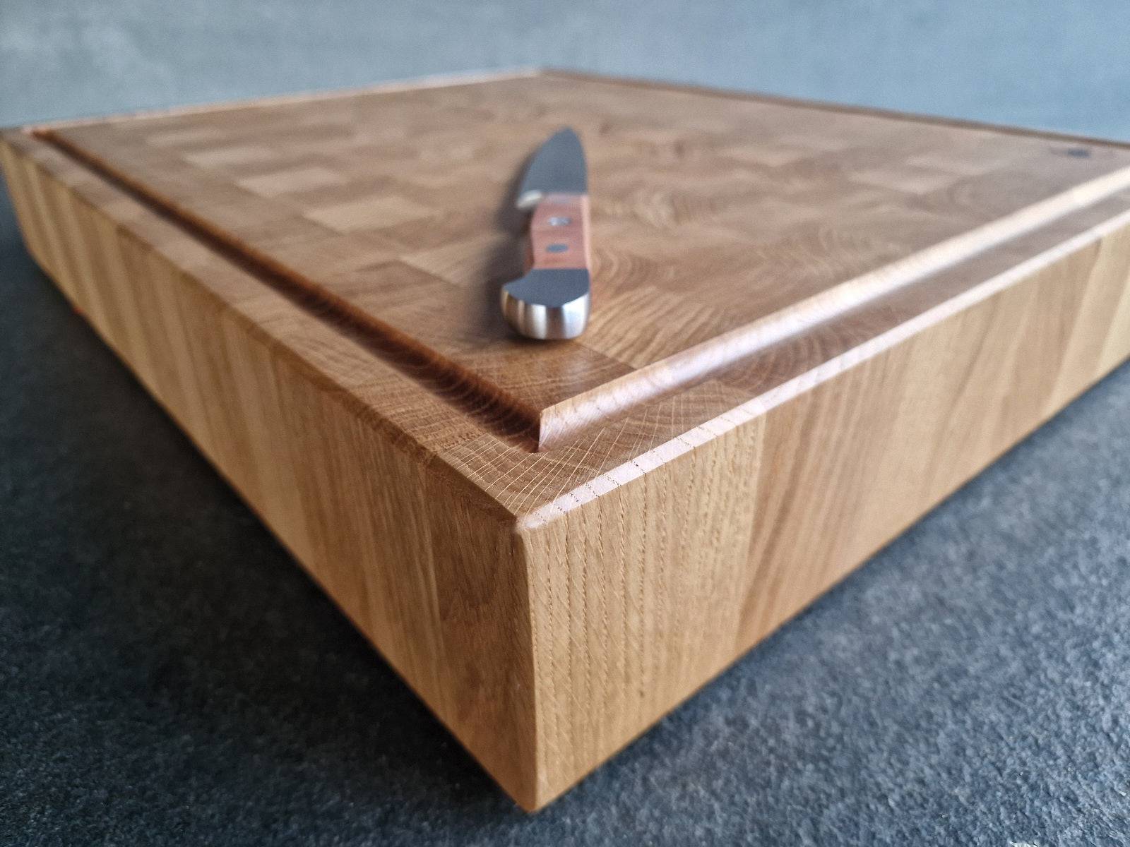 Detailansicht des ausbalancierten Birne Griffes auf einem Eiche Hirnholz Schneideblock.