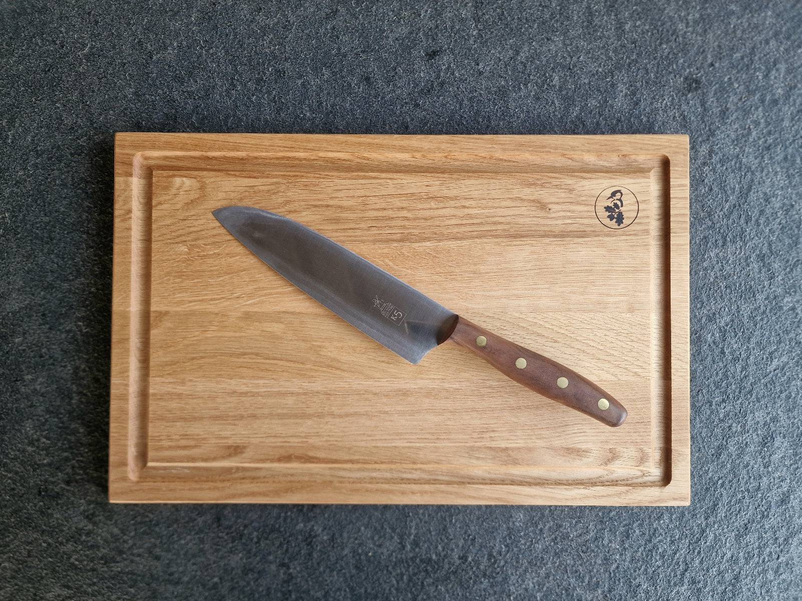 Windmühlenmesser K5 mit Walnuss-Griff auf einem Eiche Schneidebrett mit Saftrille.