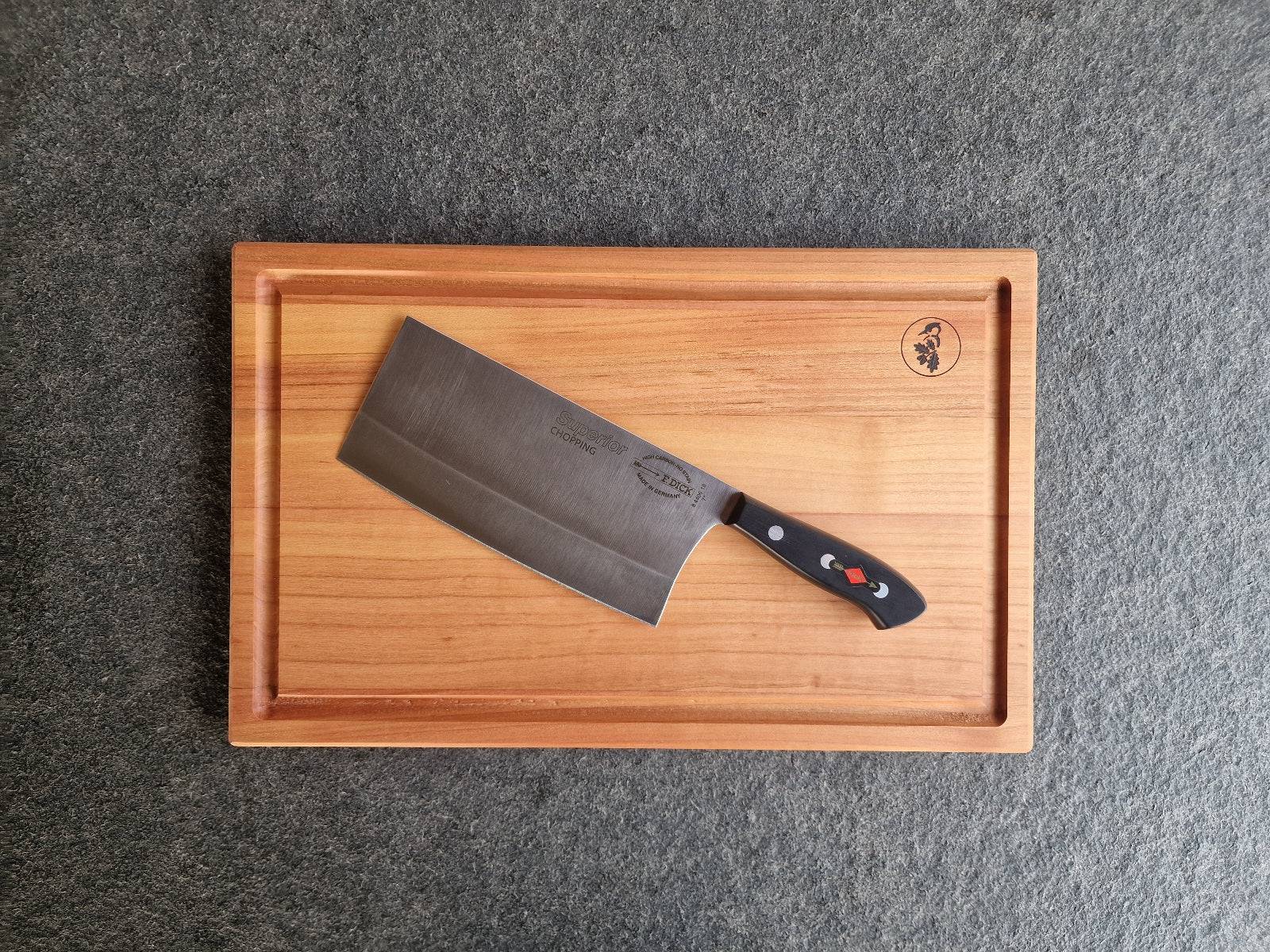 Chinesisches Kochmesser Dick Superior auf einem Saftrillenbrett aus Kirschbaum.
