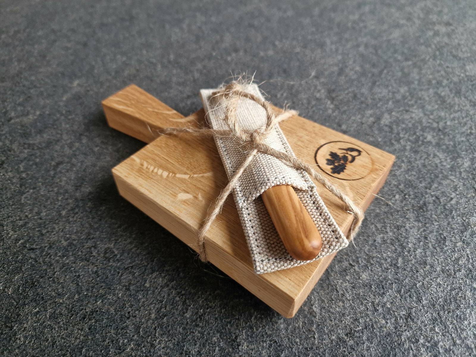 Kleines Eichenbrett mit Griff. Mit einem Windmühlenmesser mit Oliven-Griff im Leinen-Etui von Windmühlenmesser.