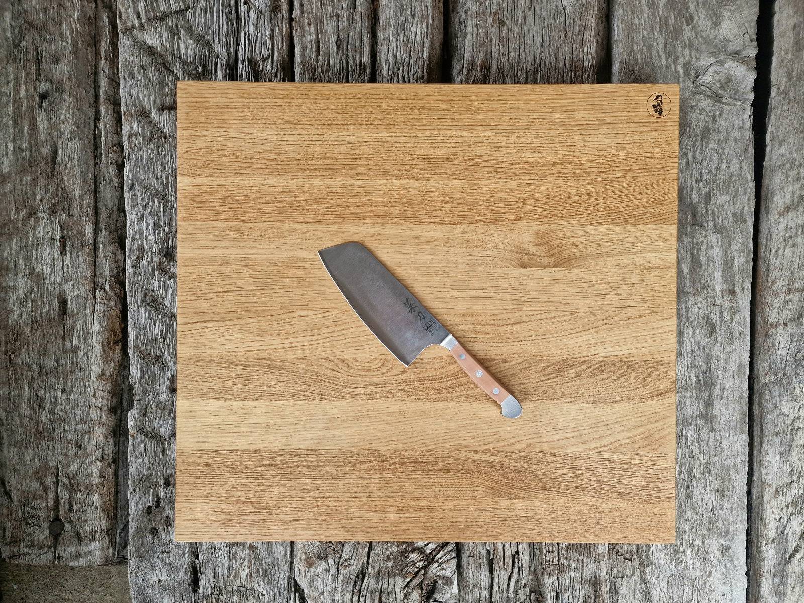 60 cm großer Eiche Schneideblock auf alten Eichenbalken. Dekoriert mit einem Güde Kochmesser Alpha mit Birne Griff.
