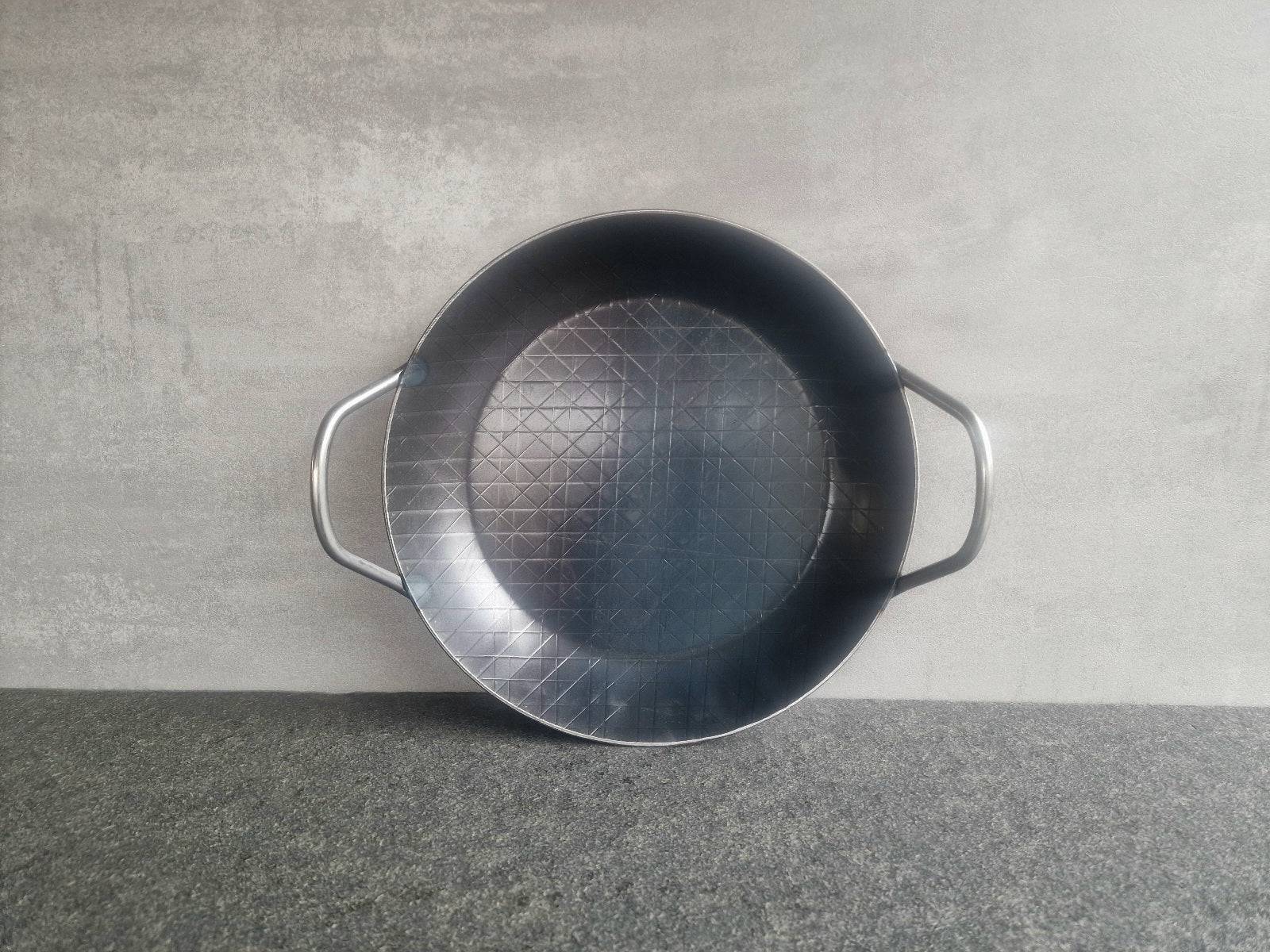 Eine Eisenpfanne mit einem Durchmesser von 28 cm. Sie hat zwei Griffe.