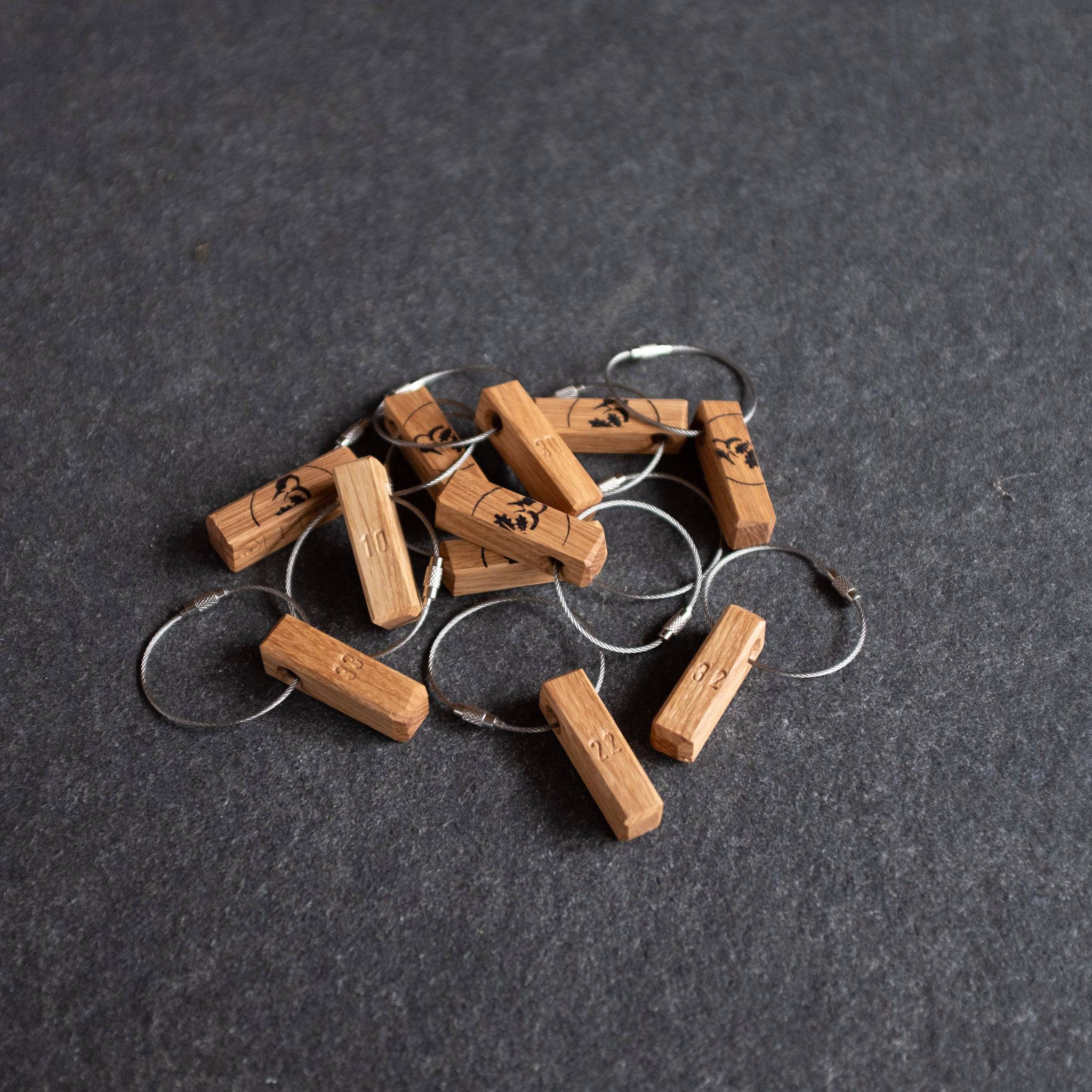 Mehrere Schlüsselanhänger aus Eiche mit Zimmernummer eingeschlagen.