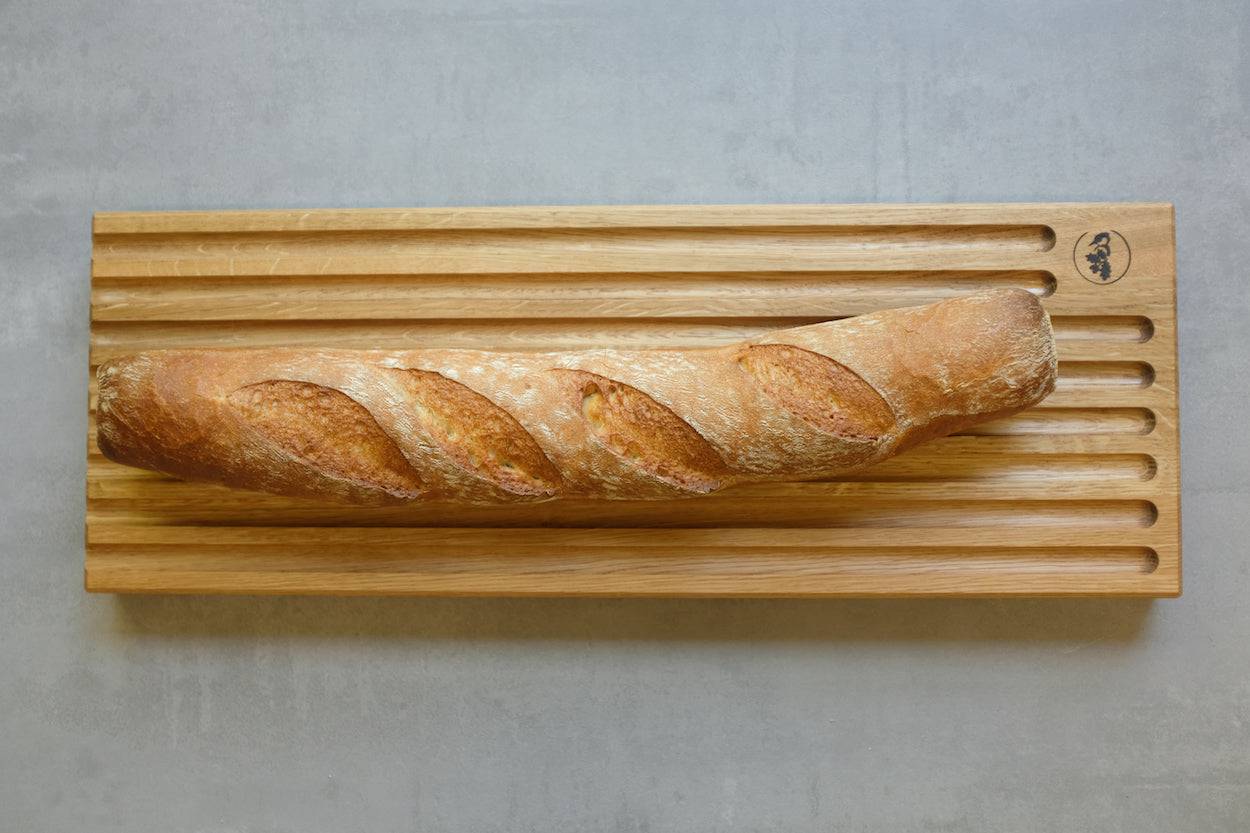 Brotschneidebrett für Baguette, von oben fotografiert mit einem knusprigen Baguette