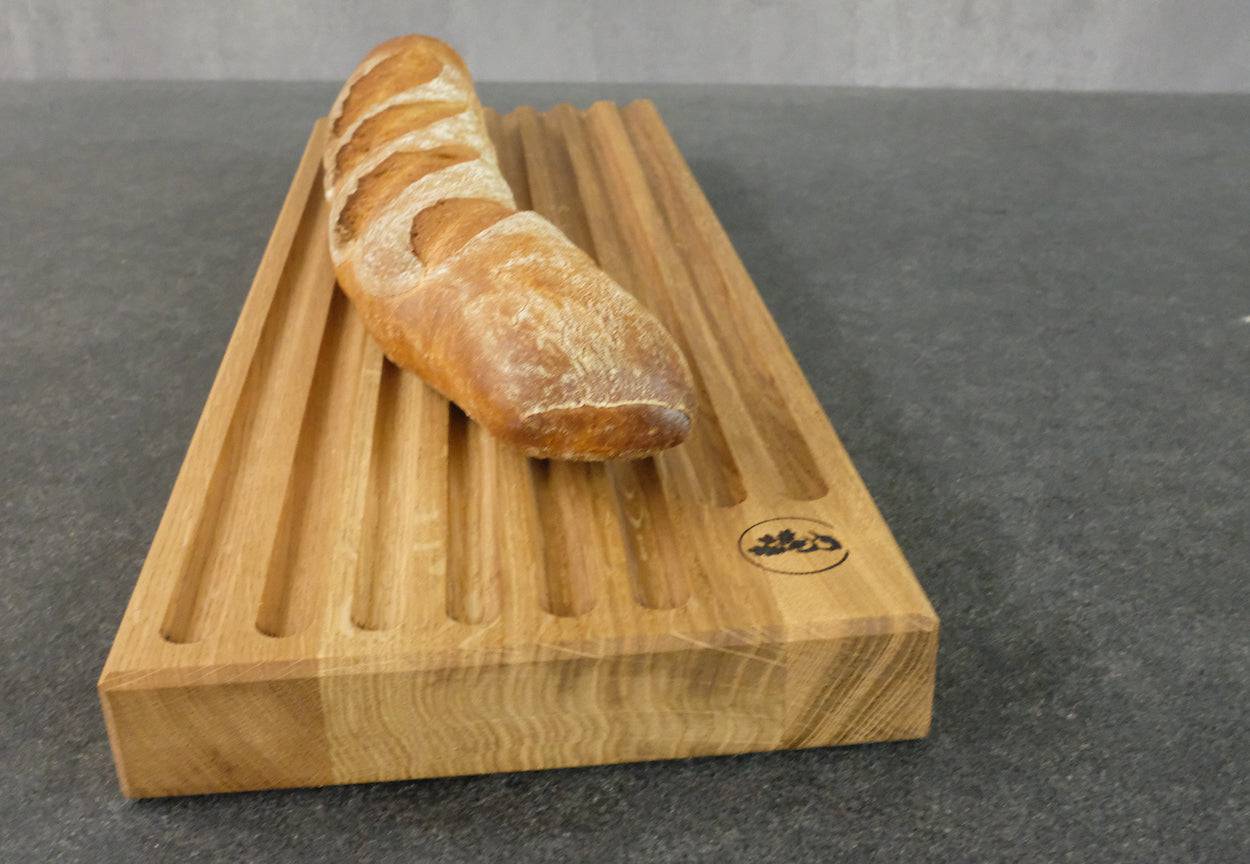 Ein Baguette auf einem Eiche Brotschneidebrett