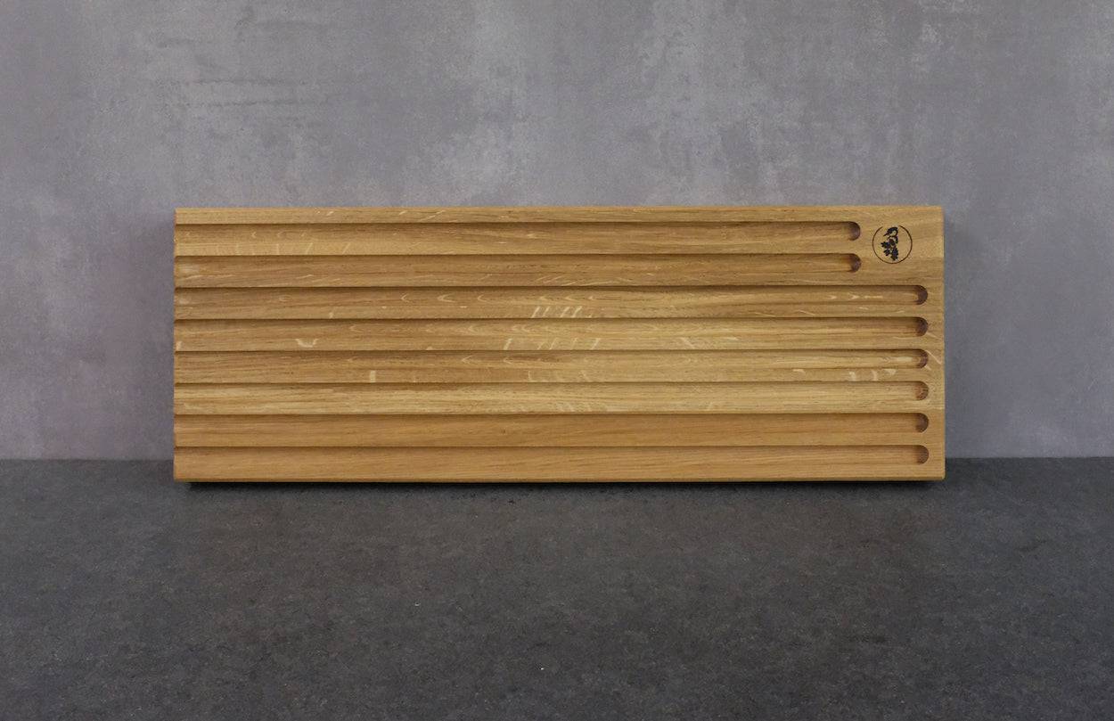 Brotschneidebrett an einer grauen Wand angelehnt.